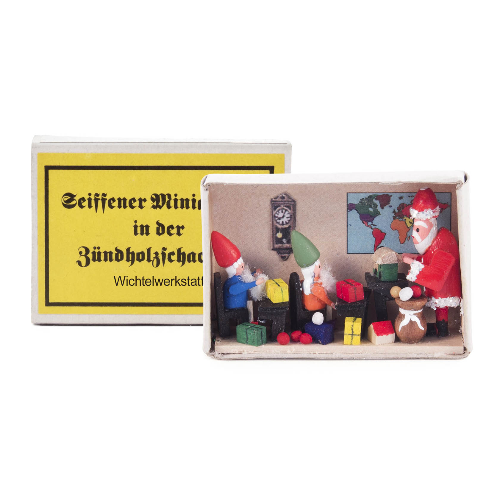 Zündholzschachtel mit Miniaturen: Zwei Wichtel und ein Weihnachtsmann basteln Geschenke an einem Tisch. Geschenkverpackungen und eine Wanduhr sind zu sehen.