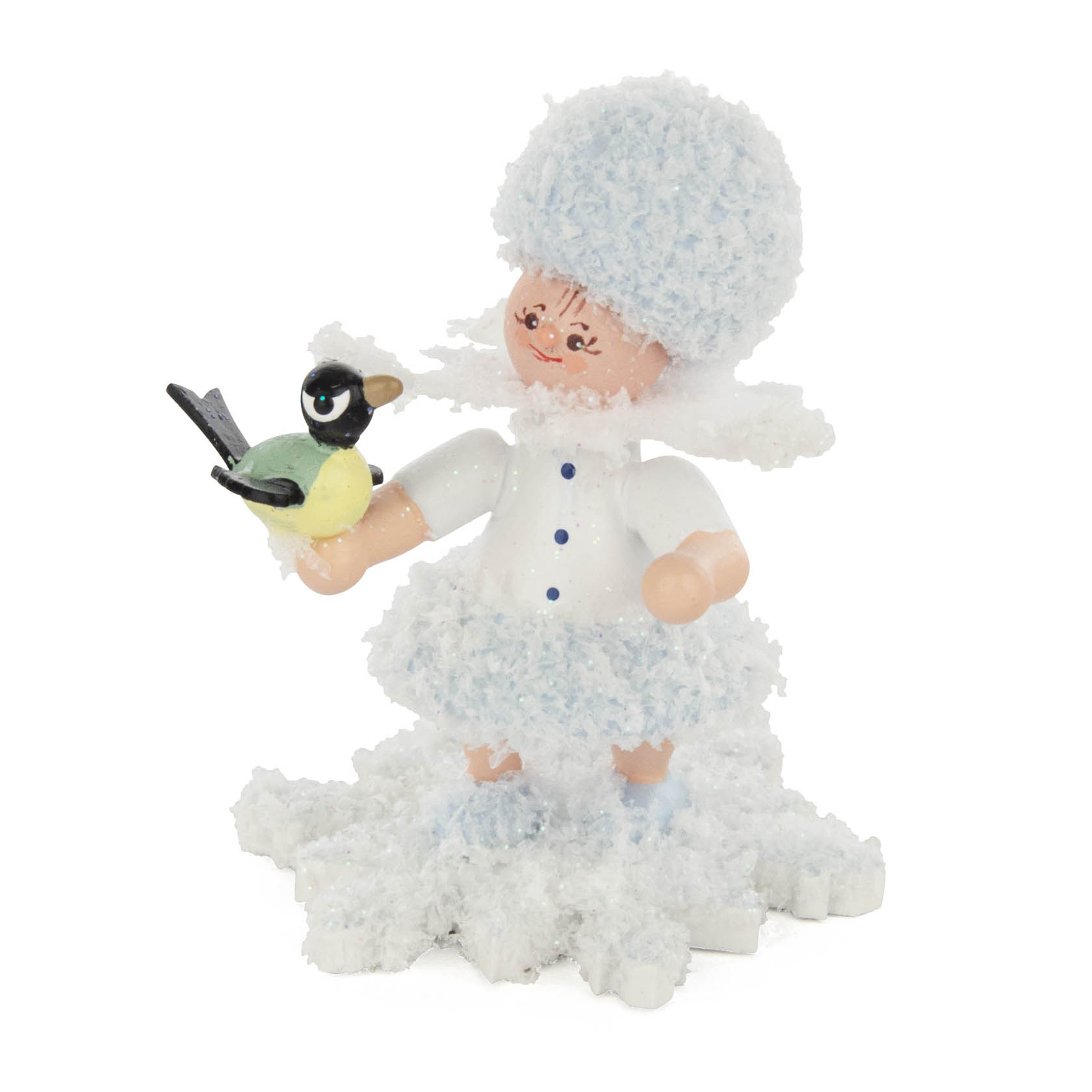 Ein Holzfigur Schneeflöckchen mit weißem Hut und Mantel, hält einen kleinen Vogel in der Hand.