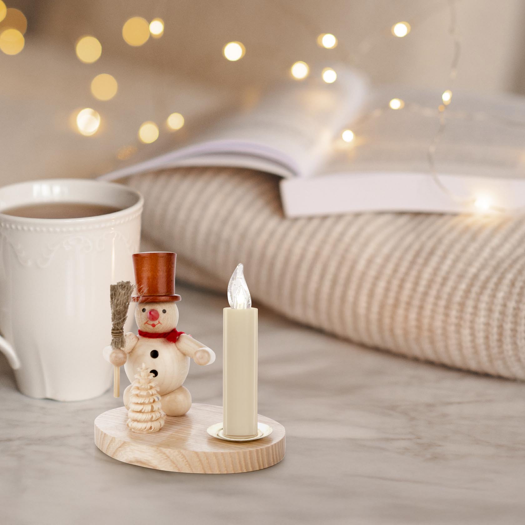 Wooden snowman candle holder with a natural finish, featuring a snowman wearing a brown top hat and holding a broom, next to a white candle.
