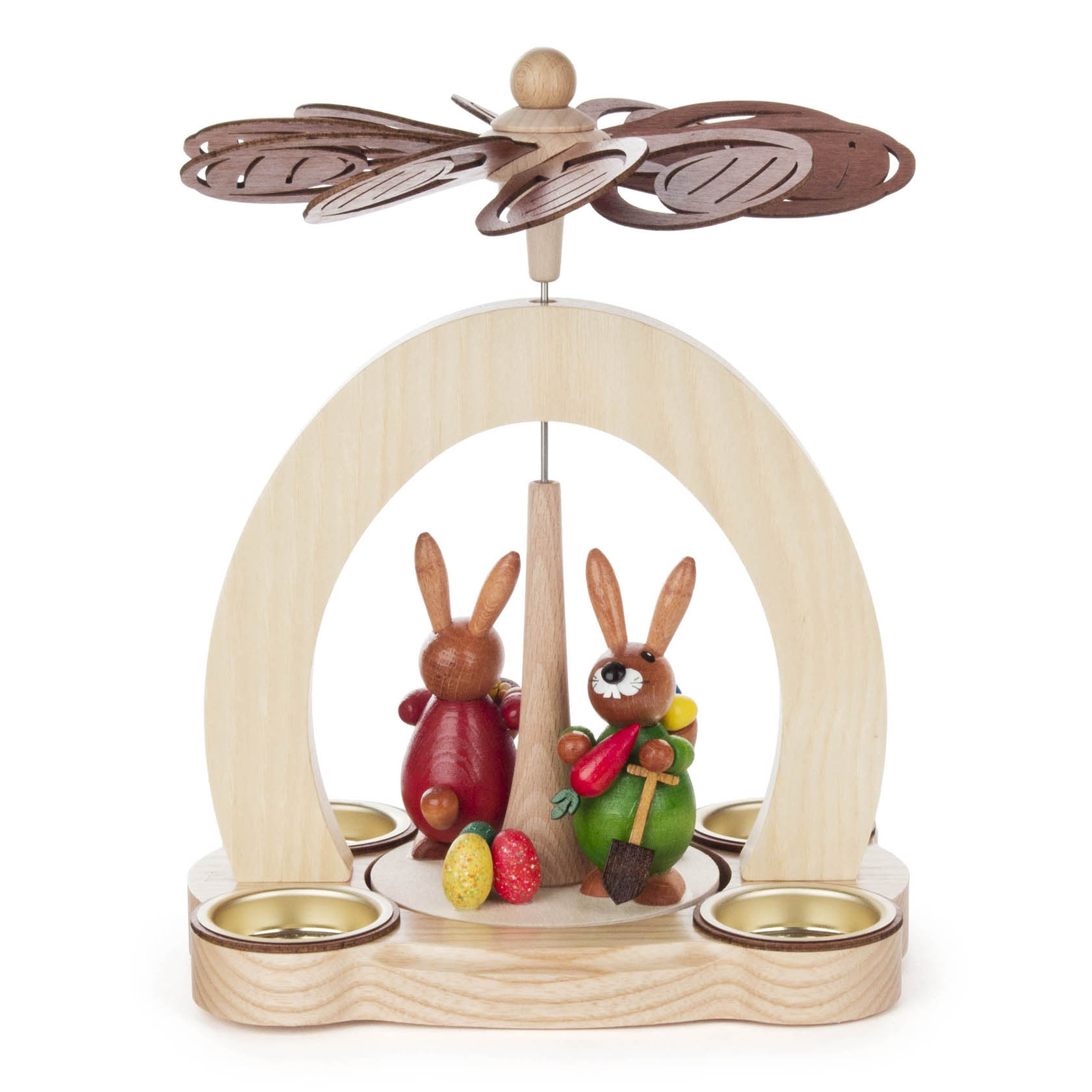 Holzpyramide mit zwei bemalten Hasenfiguren. Einer trägt rote Kleidung und der andere grüne. Sie stehen zwischen Teelichthaltern und unter einem Propeller.