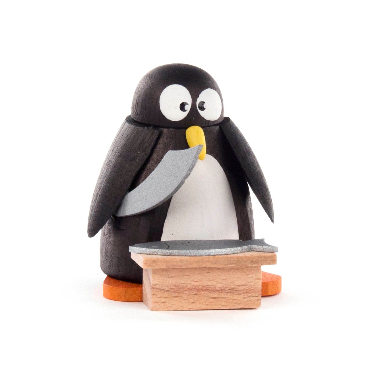 Kleiner Pinguin aus Holz steht hinter einem Holzstand und hält einen Fisch mit seinen Flügeln. im Dregeno Online Shop günstig kaufen
