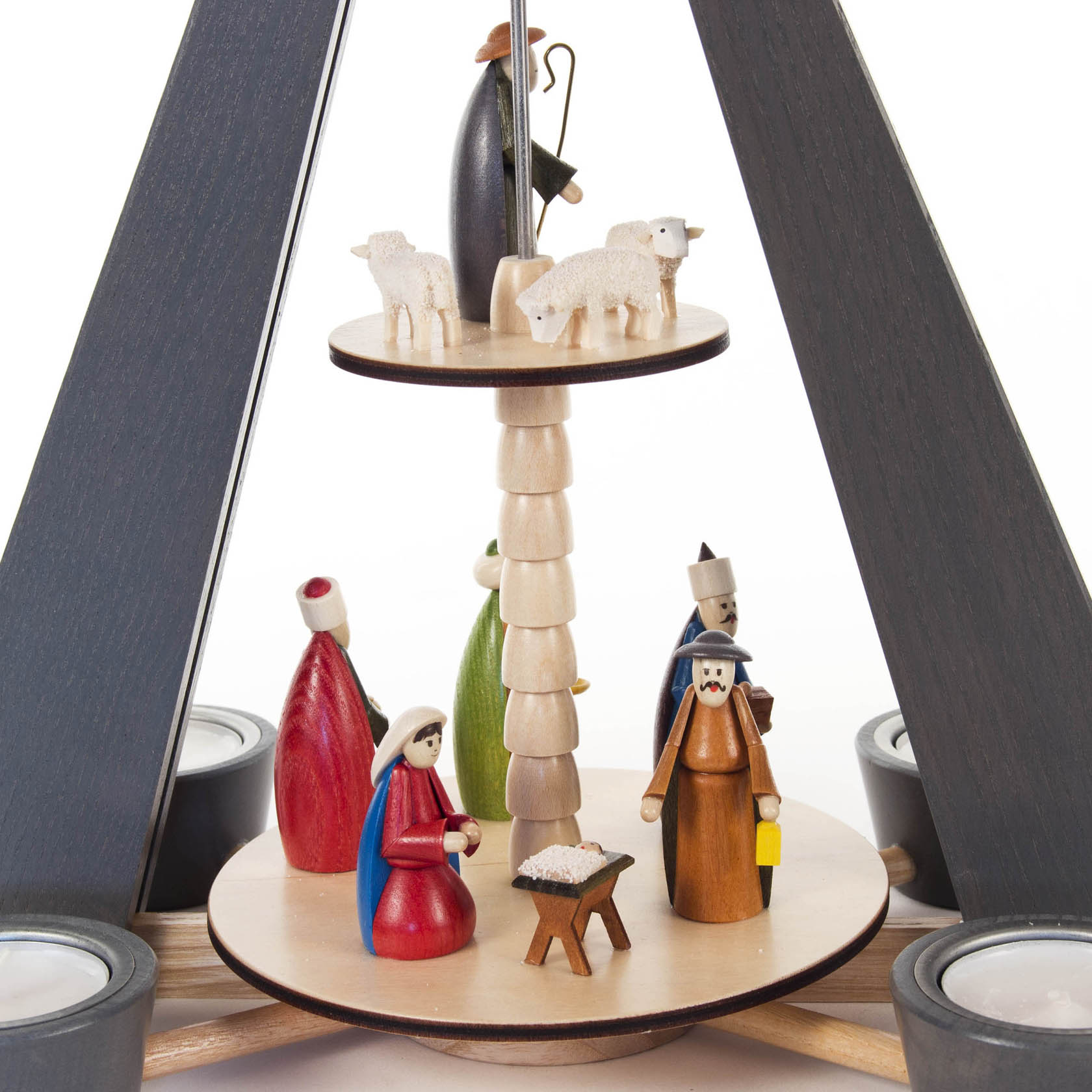 Zweistufige Weihnachtspyramide mit farbigen Holzfiguren: Hirte mit Schafen oben, Maria, Josef, Jesuskind und weitere Figuren unten.