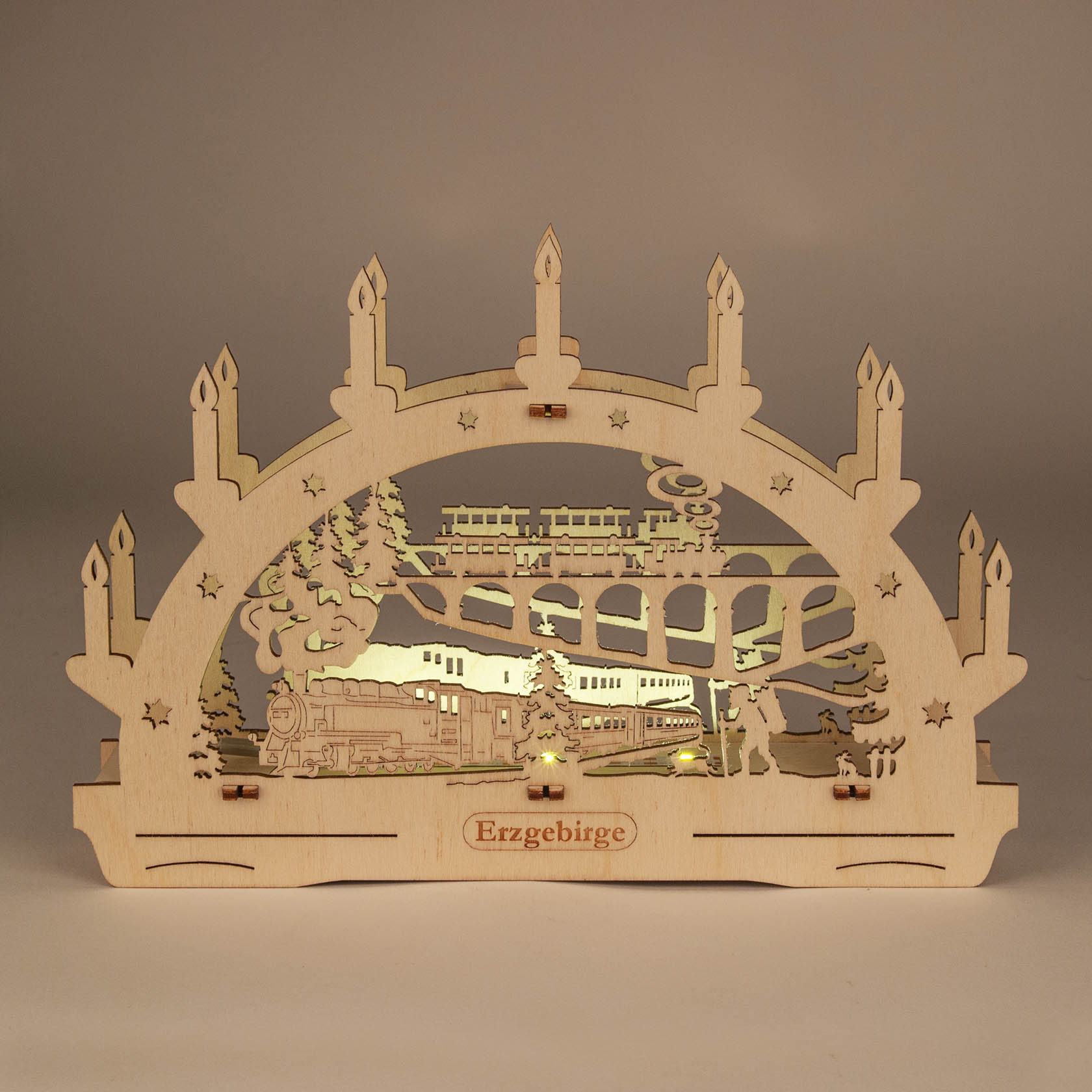 Wooden arch candleholder featuring a train motif with LED lights. A train travels through a snowy landscape with a bridge and trees.