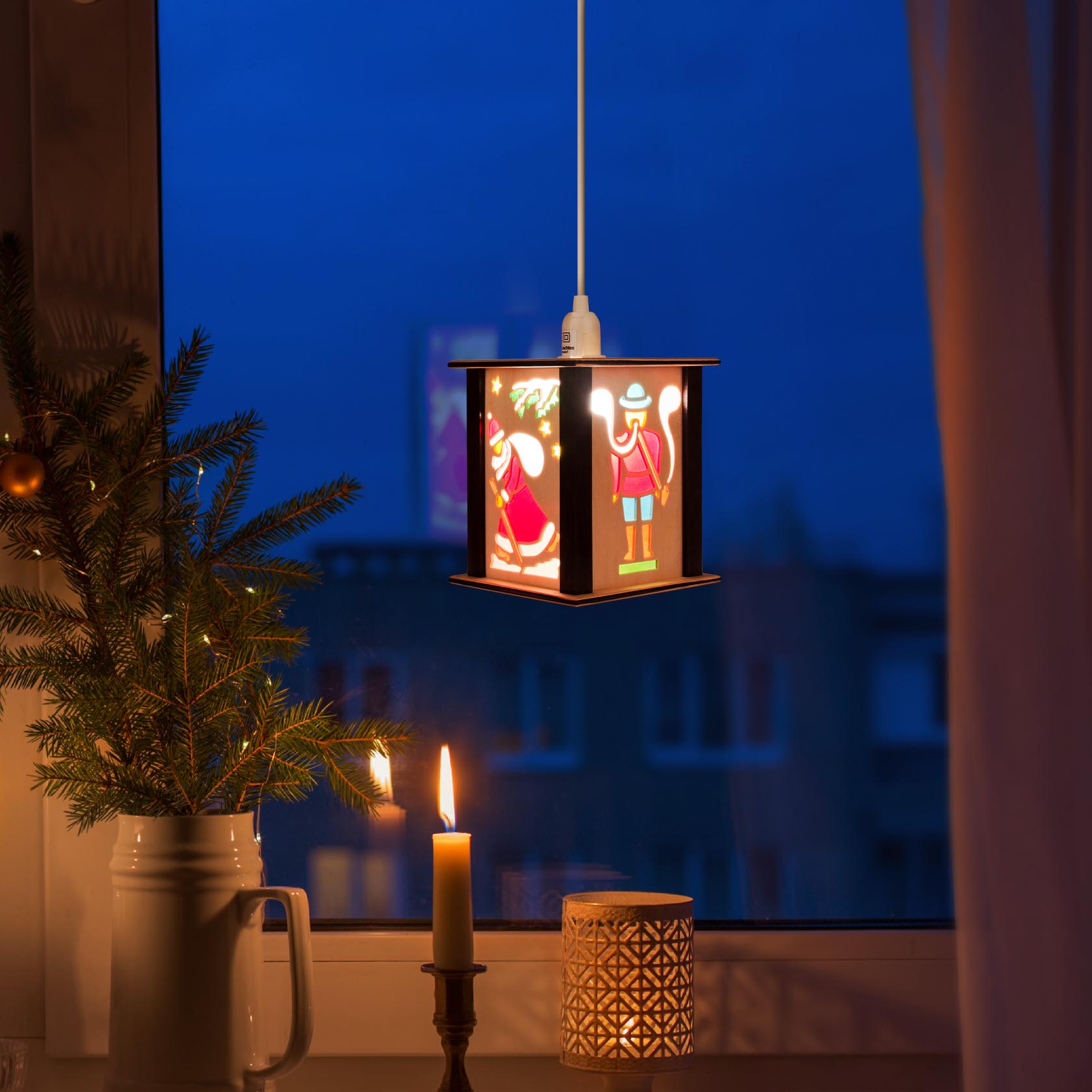 Small nutcracker-themed lantern hanging in a window, illuminating the scene with a warm glow. A lit candle and festive decorations are nearby.