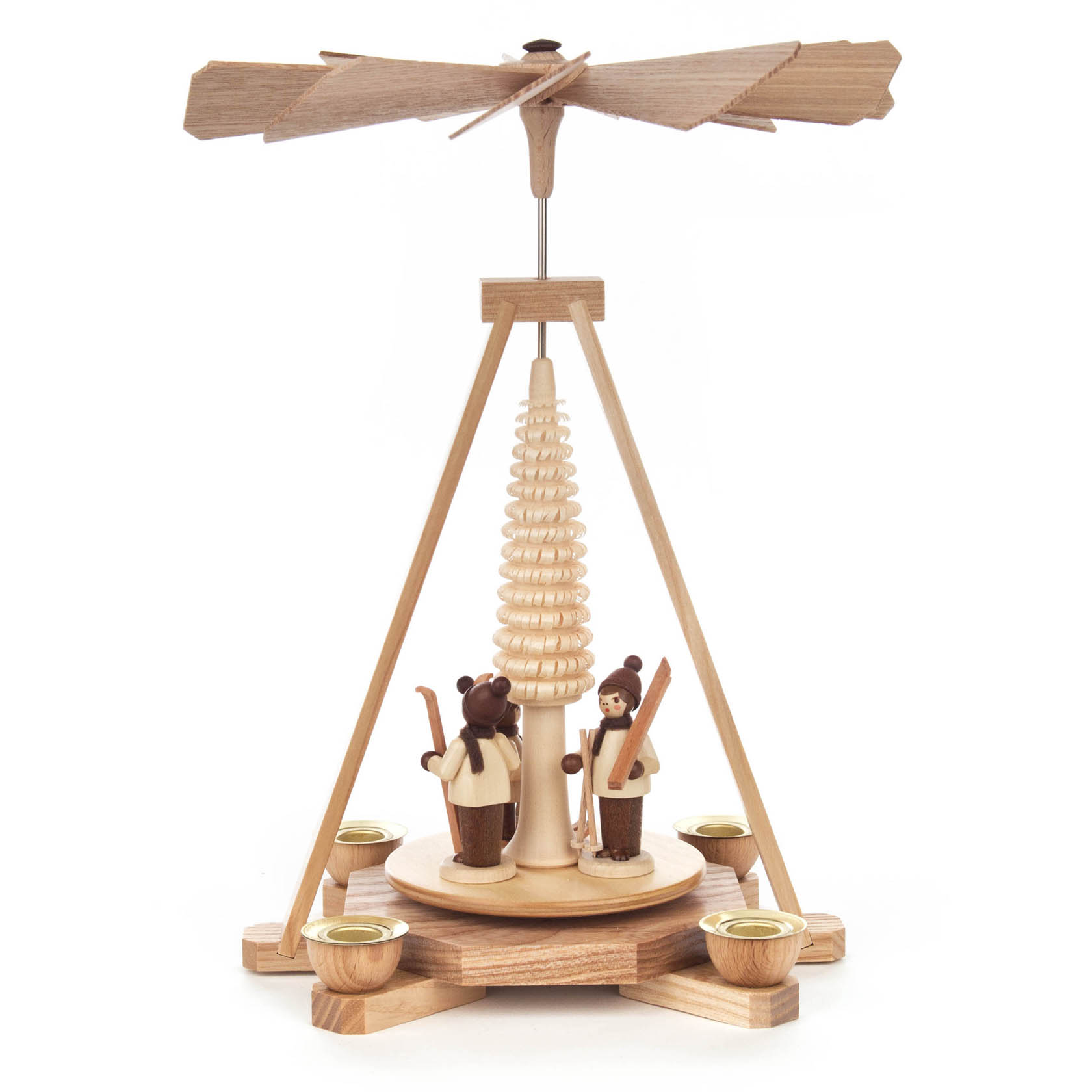 A wooden Christmas pyramid featuring two skier figurines in winter attire, standing under a small pine tree with a propeller on top.