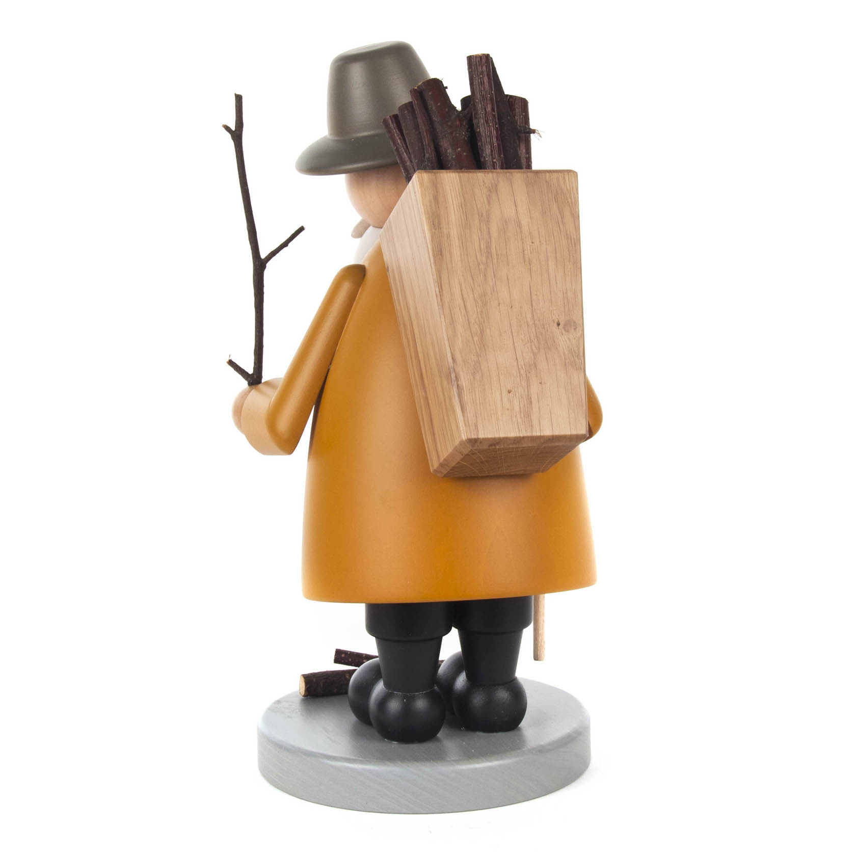 Ein Räuchermann in Form eines Holzsammlers trägt einen Holzbündel auf dem Rücken und hält einen Ast in der Hand.