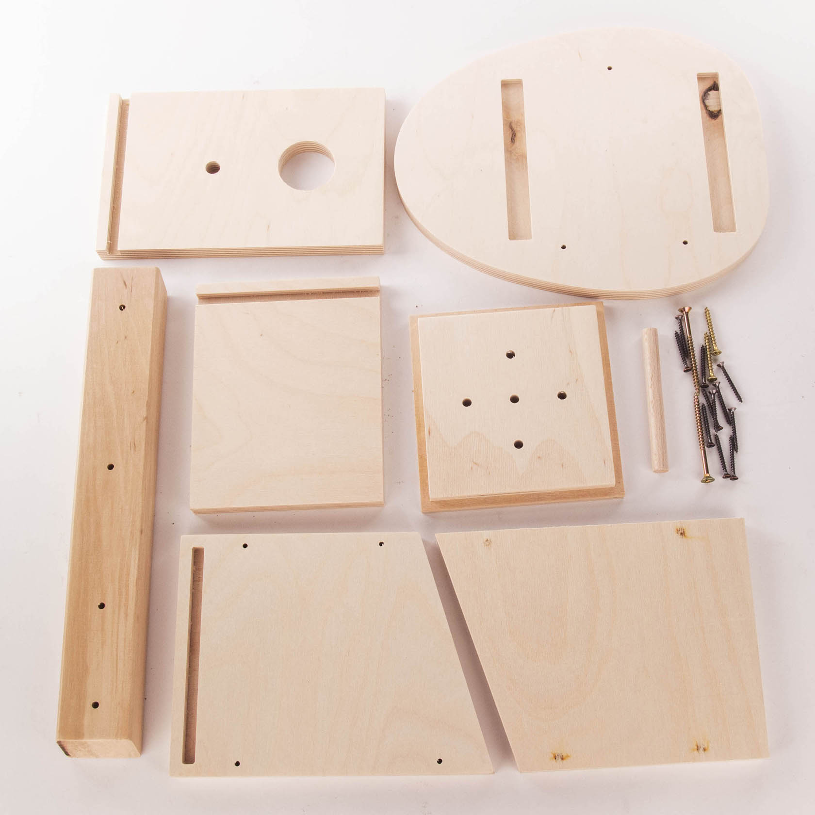 Birdhouse construction kit containing several pre-cut wooden pieces, a dowel, and assorted screws and nails, arranged on a flat surface.