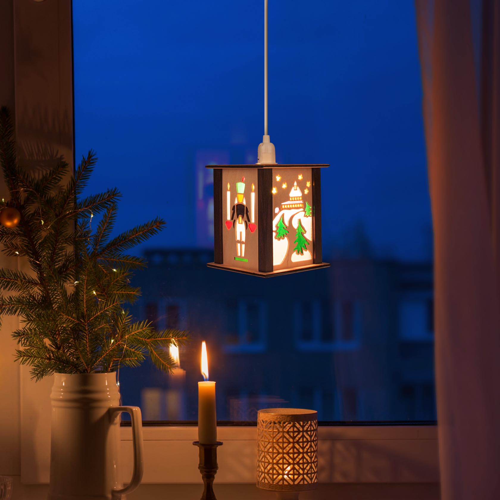 Small lantern featuring the Seiffen Church, with a night backdrop, illuminated by a candle and a small pine tree nearby.