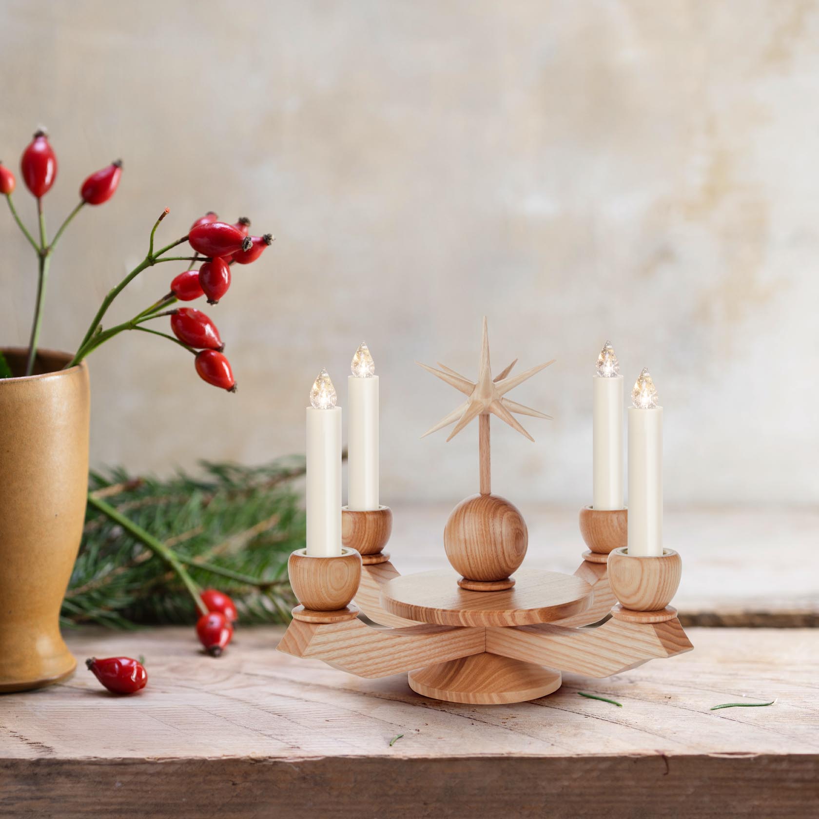 Adventsleuchter aus hellem Holz mit fünf Kerzenhaltern und einem zentralen Stern. Die Kerzen sind weiß und es gibt eine Dekoration aus Zweig und Hagebutte daneben.