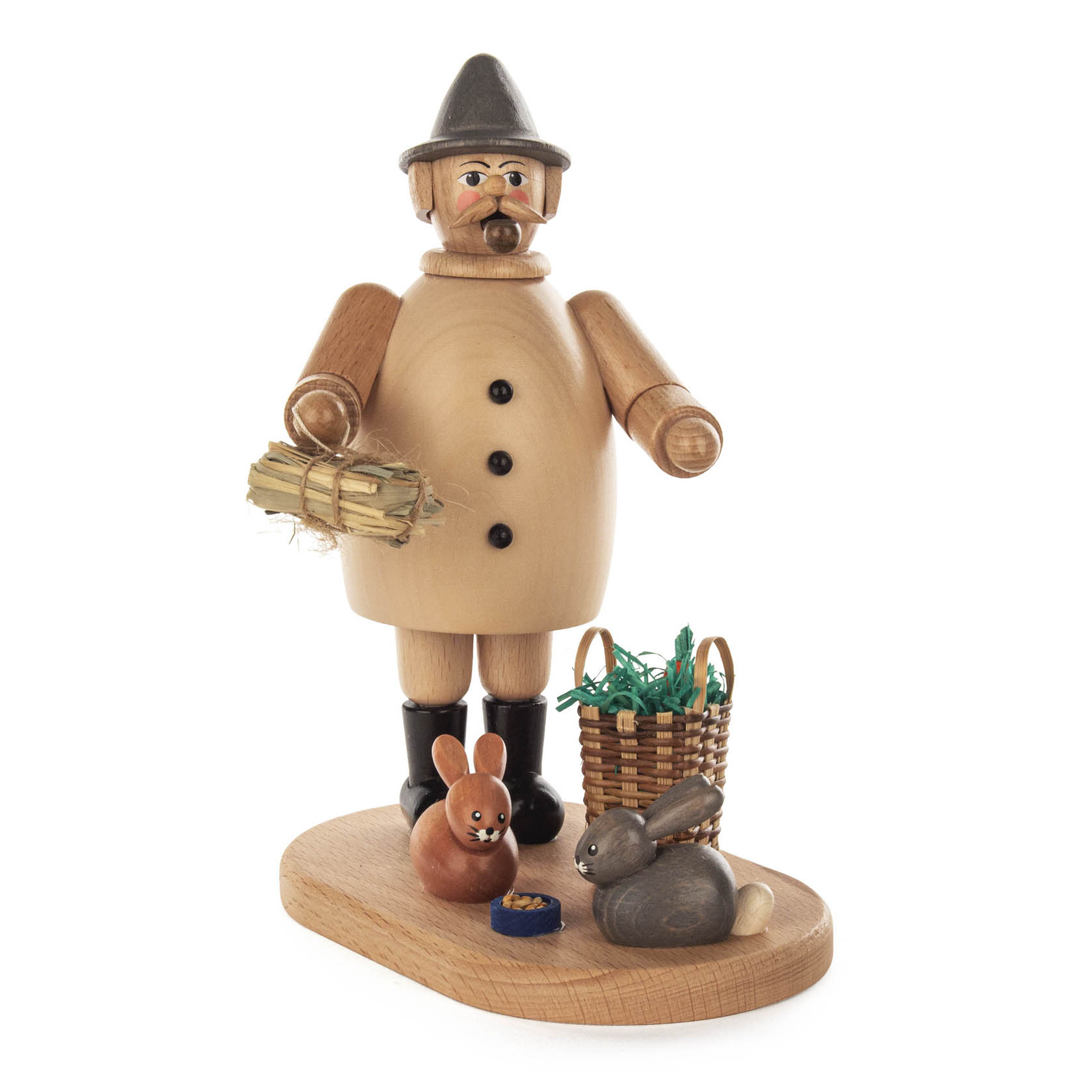 Holzfigur eines Kaninchenzüchters mit Pfeife, blauem Hut und Mantel, hält Heubündel in der Hand, neben zwei Kaninchen und einem Korb auf Holzsockel.
