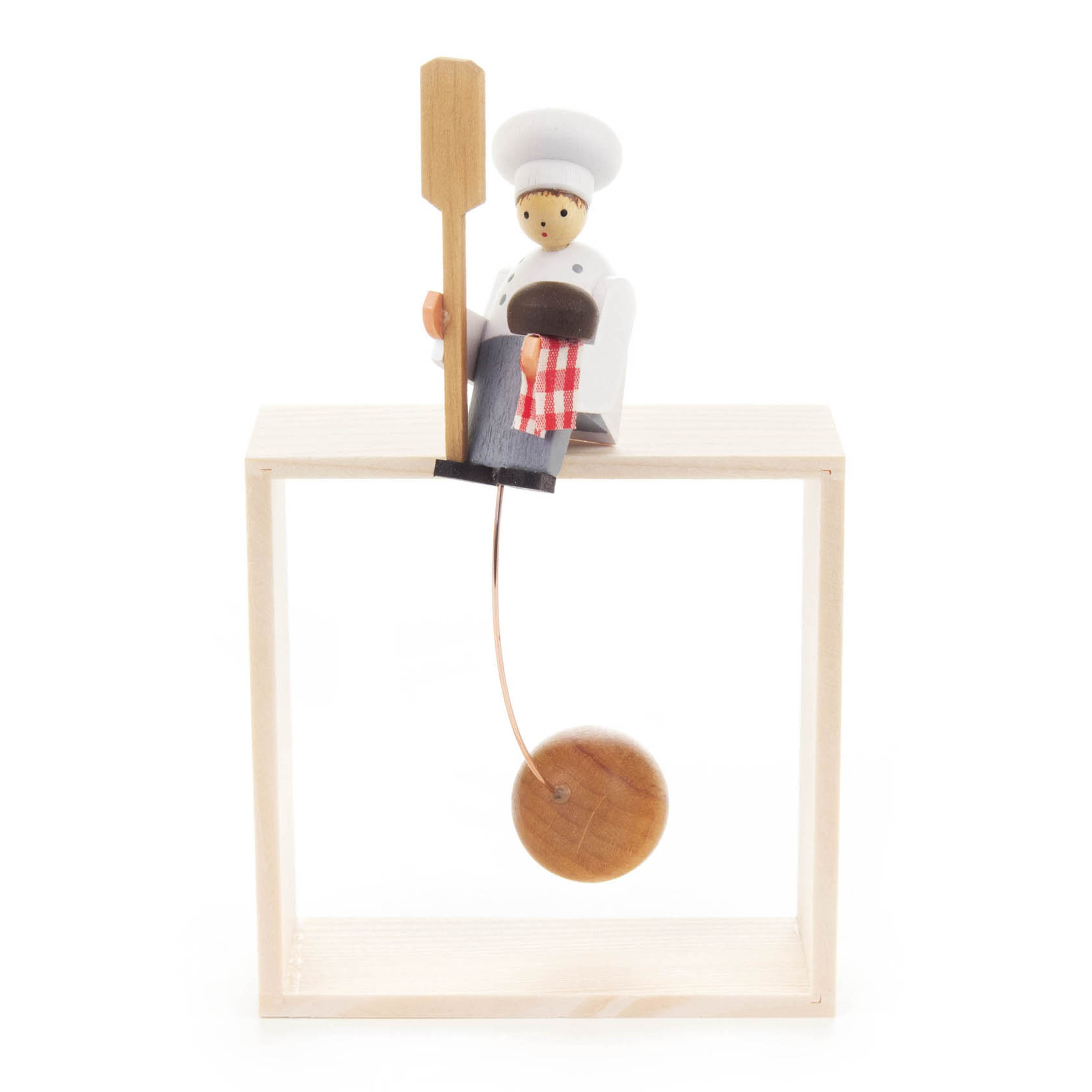 Holzfigur eines Bäckers mit Bäckerhut, der auf einem Holzrahmen sitzt. Er hält einen Brotschieber und hat ein Brot neben sich. Am Rahmen hängt ein Holzgewicht.