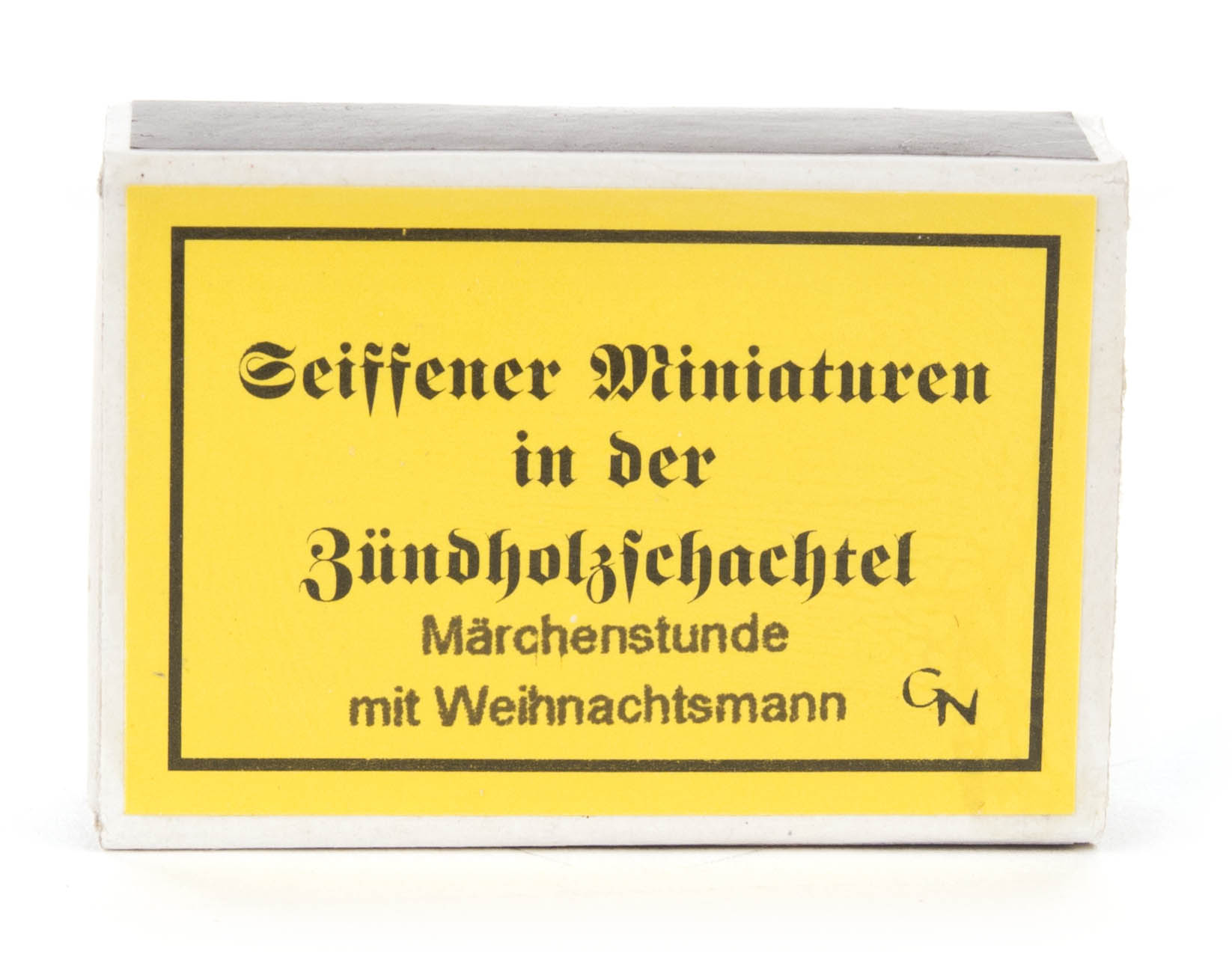 Gelbe Schachtel mit der Aufschrift 'Seiffener Miniaturen in der Zündholzschachtel Märchenstunde mit Weihnachtsmann'