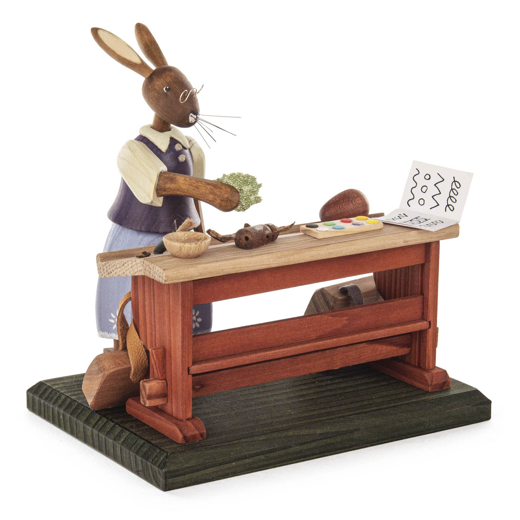 Holzfigur eines Hasenkindes Nr.5. Es steht hinter einer Holzschulbank mit Büchern, Kugeln und einer Schiefertafel, trägt eine blaue Latzhose und ein gelbes Hemd. im Dregeno Online Shop günstig kaufen