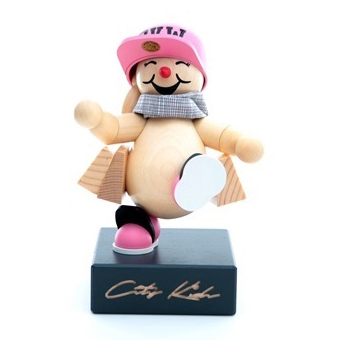 Eine fröhliche Holzfigur mit pinkem Basecap und Schuhen, die auf einem Sockel mit 'City Kids' Beschriftung steht. im Dregeno Online Shop günstig kaufen