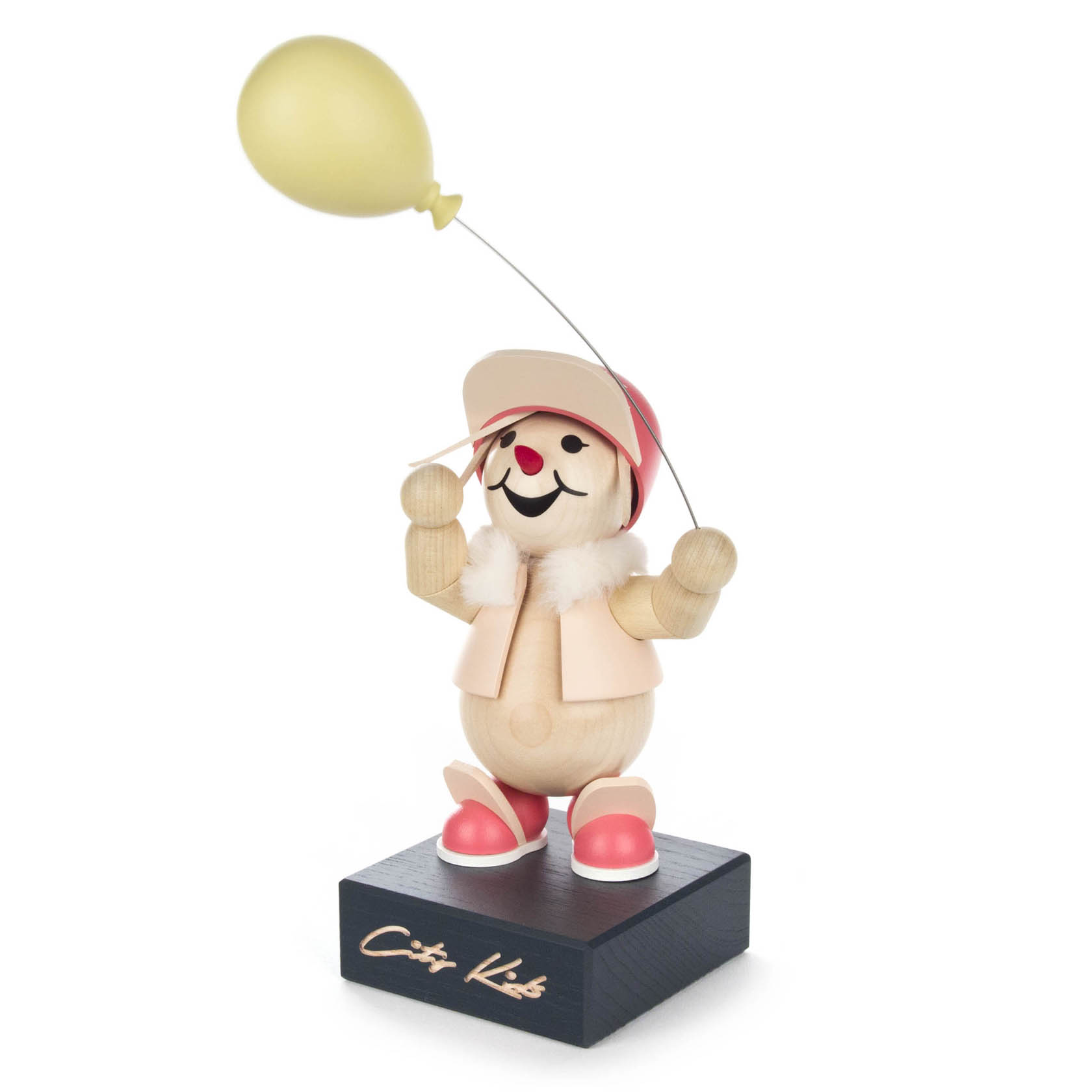 Holzfigur eines fröhlichen Kindes mit roter Kappe, rosa Weste, roten Schuhen und gelbem Ballon, auf einem Sockel mit der Inschrift 'City Kids'. im Dregeno Online Shop günstig kaufen