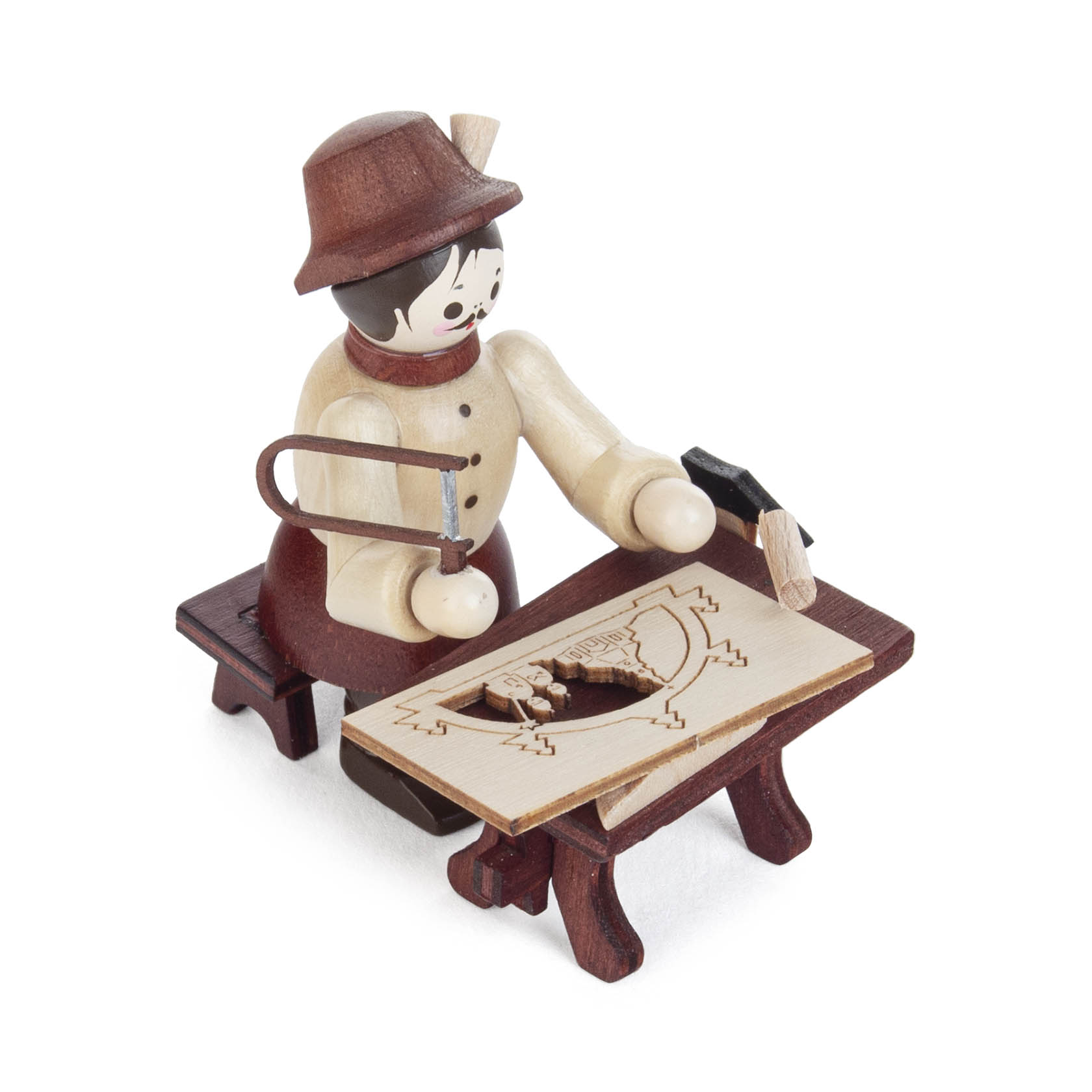 A wooden figurine of a craftsman in traditional attire, seated at a workbench, carving a Schwibbogen with a saw and hammer.