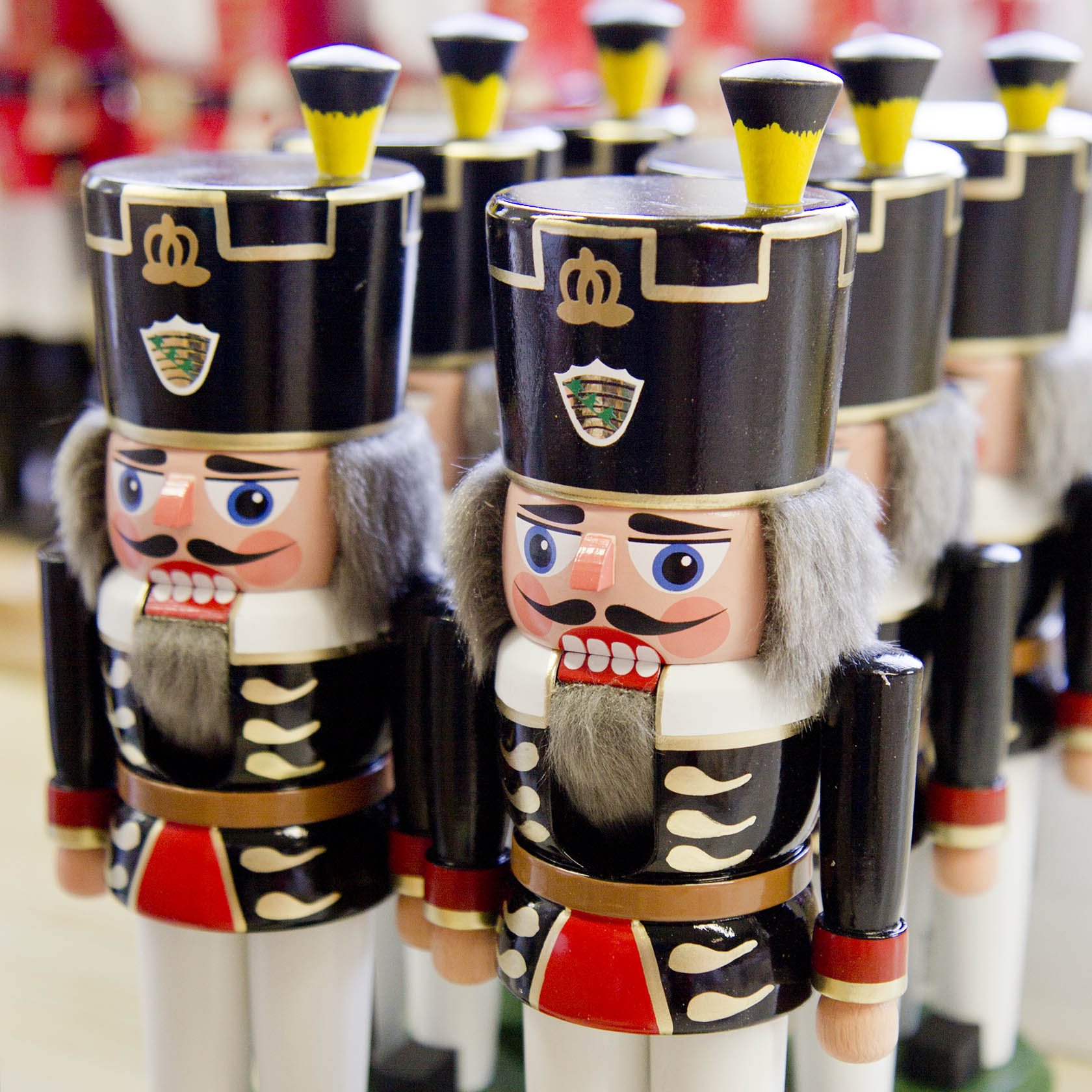 Row of traditional black and white Bergmann nutcrackers with detailed facial expressions, tall hats, and uniforms, measuring 24 cm tall.