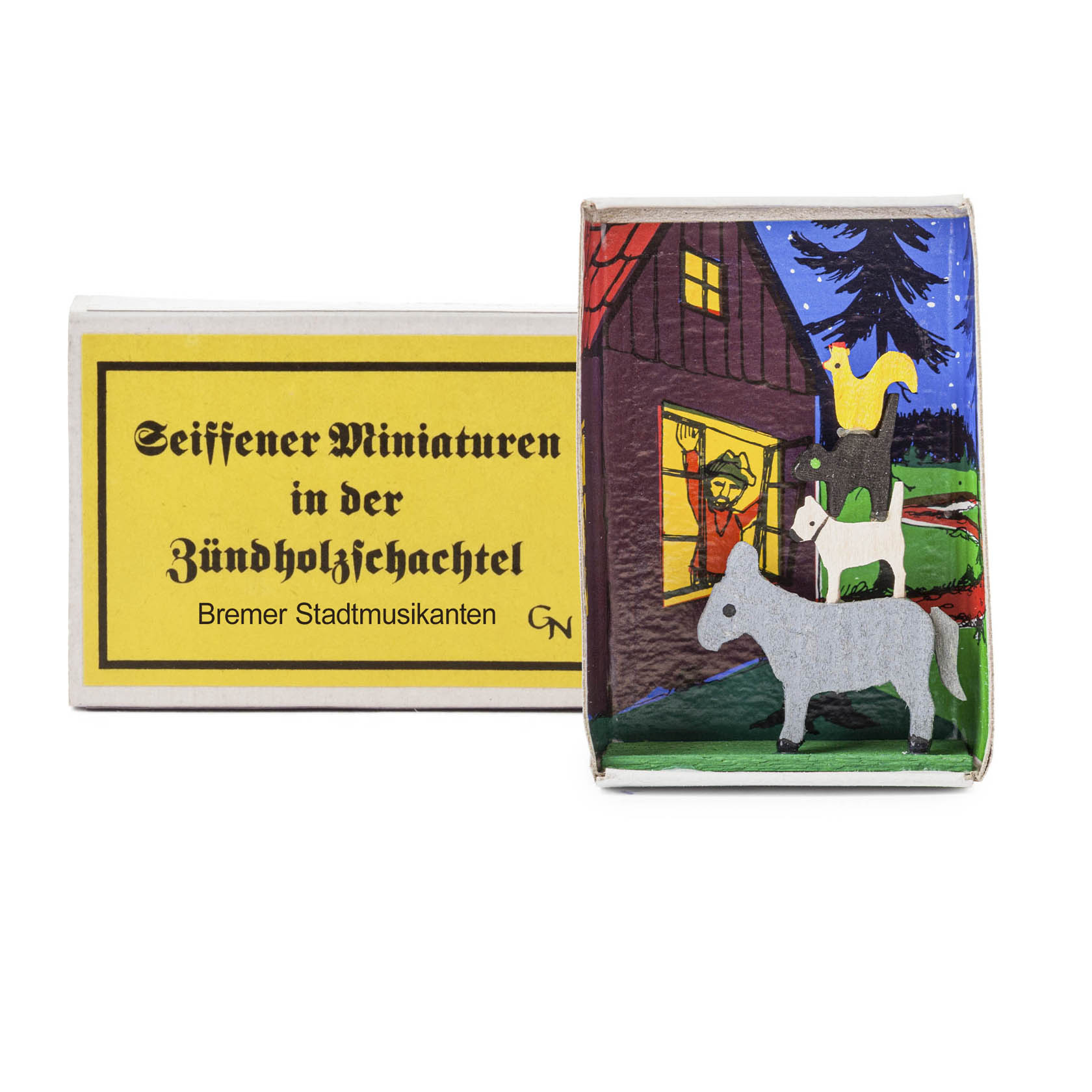 A matchbox featuring figurines of the Bremen Town Musicians: a donkey, dog, cat, and rooster stacked in front of a house.