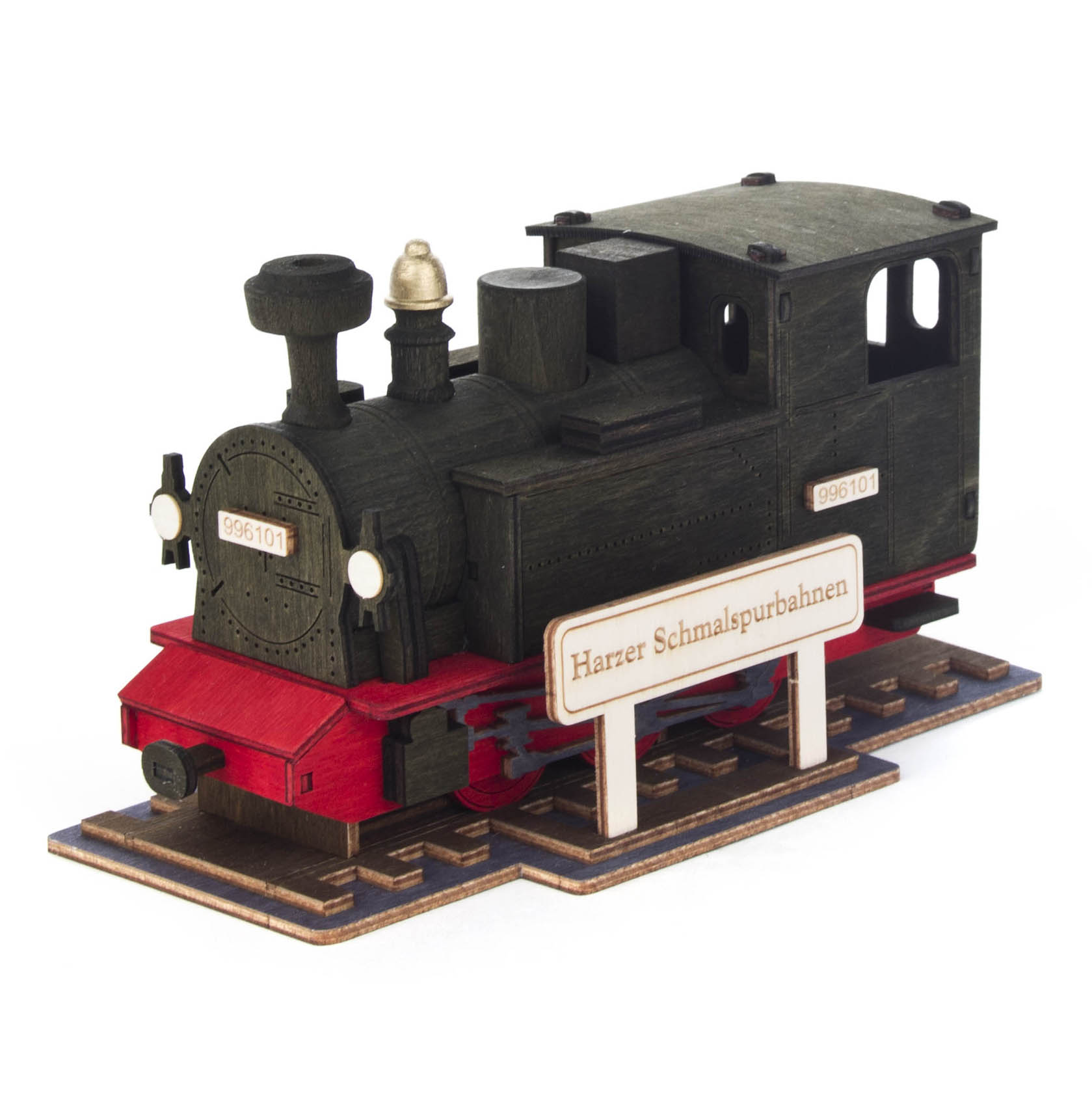 Ein Modell einer schwarzen Räucherlok mit rotem Unterbau, einem Schild mit der Aufschrift 'Harzer Schmalspurbahnen' und einem kleinen Schornstein oben. im Dregeno Online Shop günstig kaufen