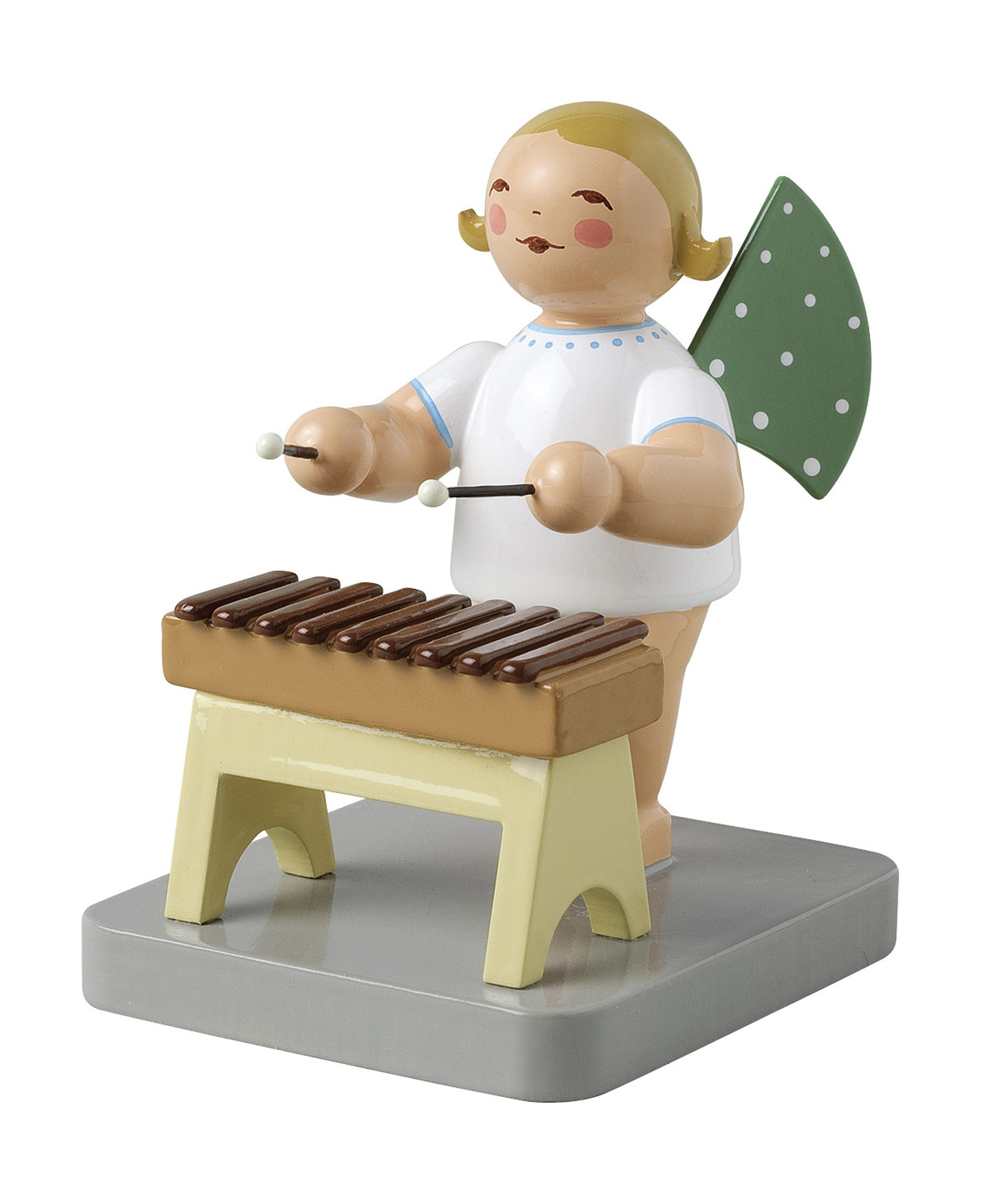 A wooden angel figurine with blond hair, dressed in white, playing a small brown xylophone with green polka-dot wings. im Dregeno Online Shop günstig kaufen