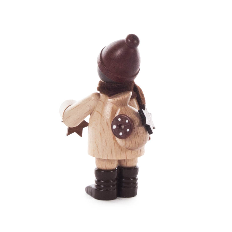 Holzfigur eines Kindes mit brauner Mütze und Schal, in der linken Hand eine kleine Rolle. Auf dem Rucksack befindet sich ein Verzierung in Form von Lebkuchen.