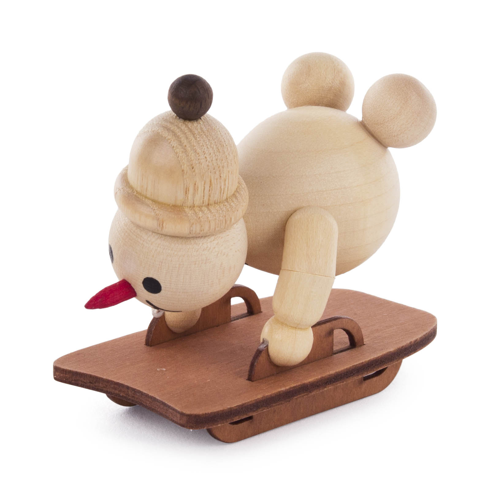 Holzfigur eines Schneemanns in gebückter Haltung auf einem Schlitten, mit einer Mütze und Karottennase.
