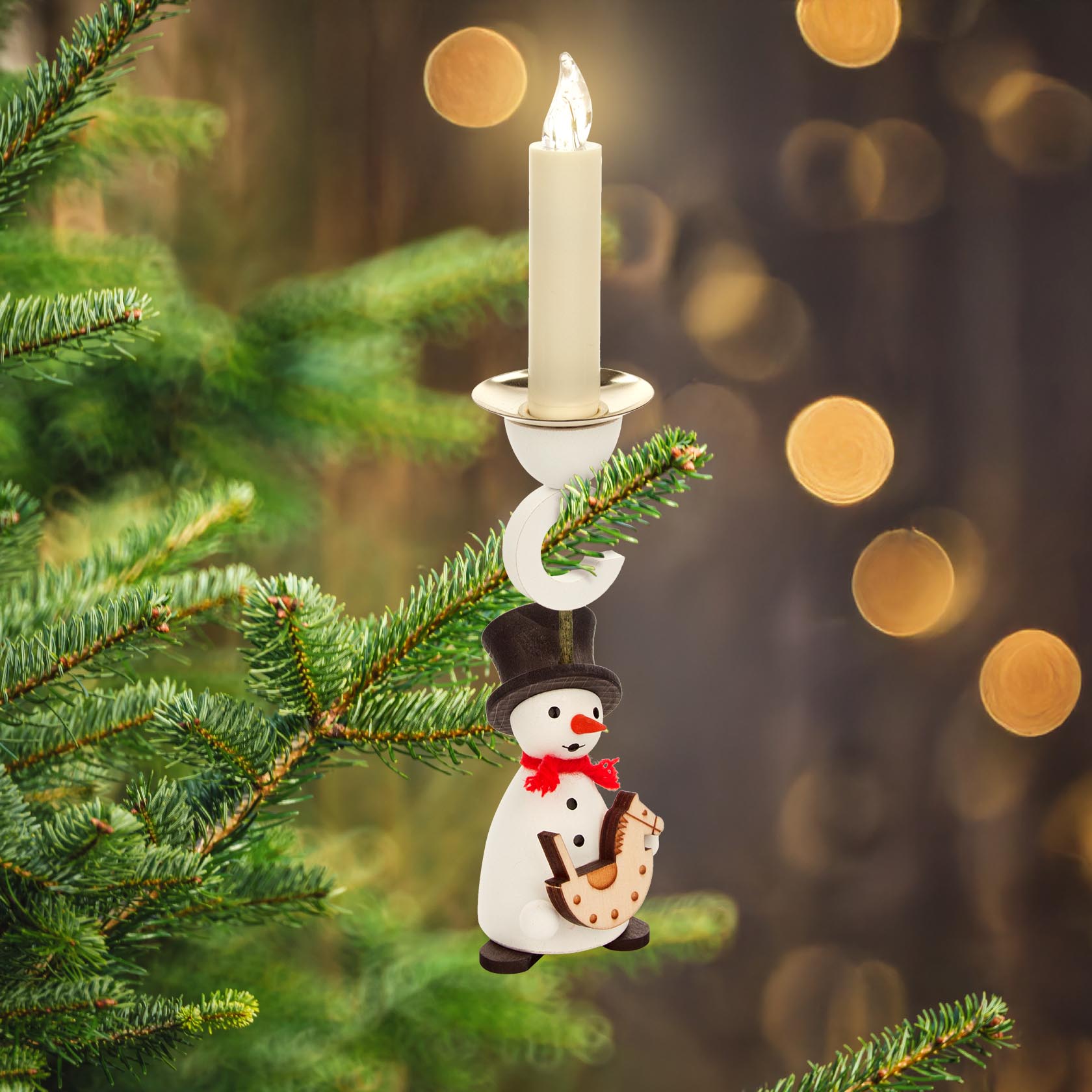 Hanging candle holder shaped like a snowman with a top hat and a red scarf, holding a toy rocking horse. Suitable for 14mm candles.