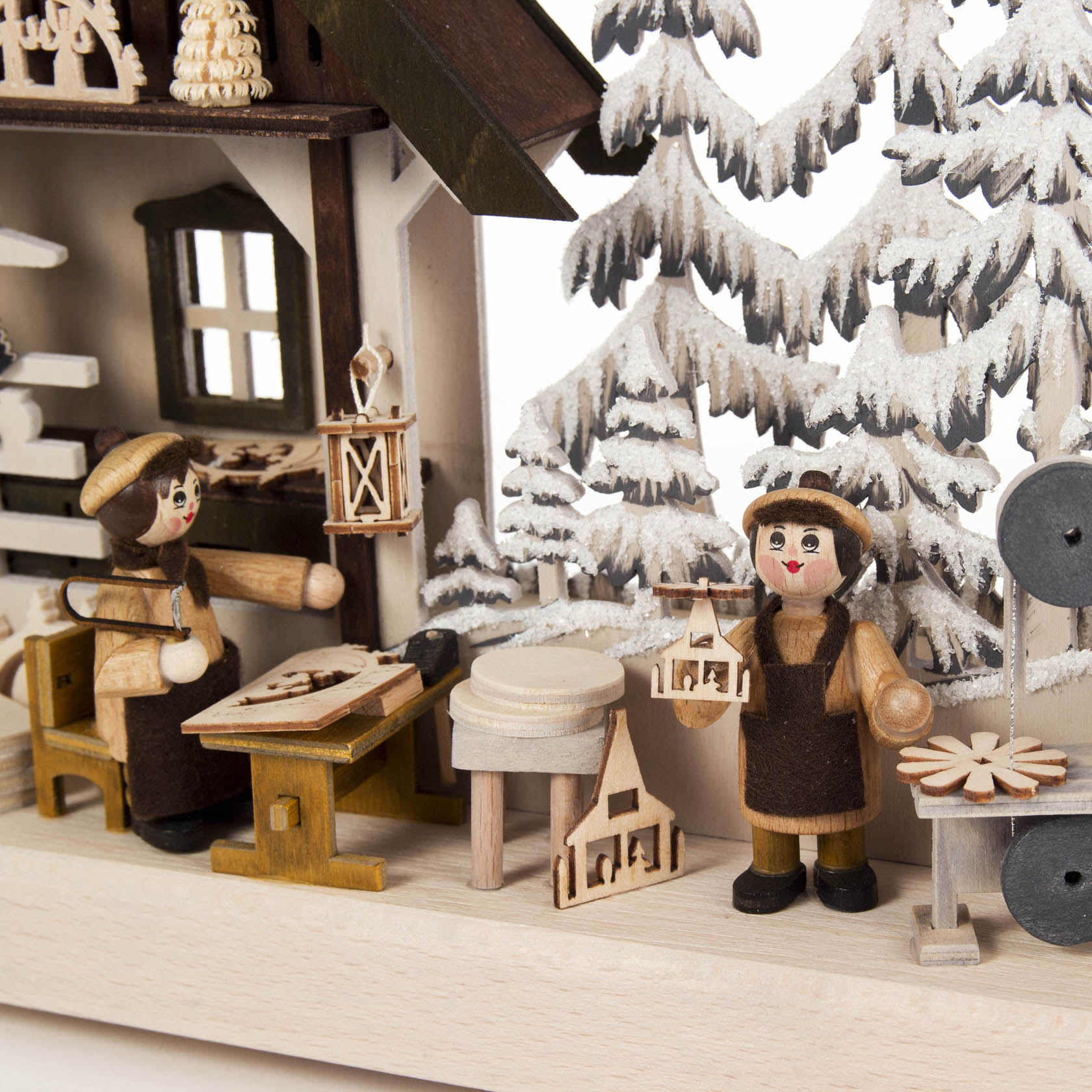 A small gray 3D Schwibbogen art piece with frost detailing and LED lighting, depicting two wooden artisan figures crafting in a workshop.