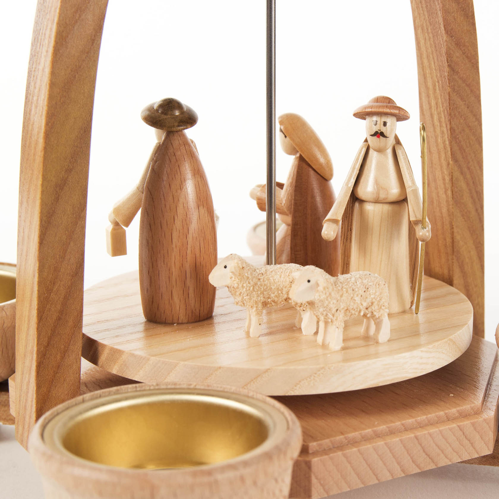 Holzpyramide mit Darstellung der Geburt Christi, drei Figuren, zwei Schafe und Teelichthalter. Figuren tragen traditionelle Kleidung.
