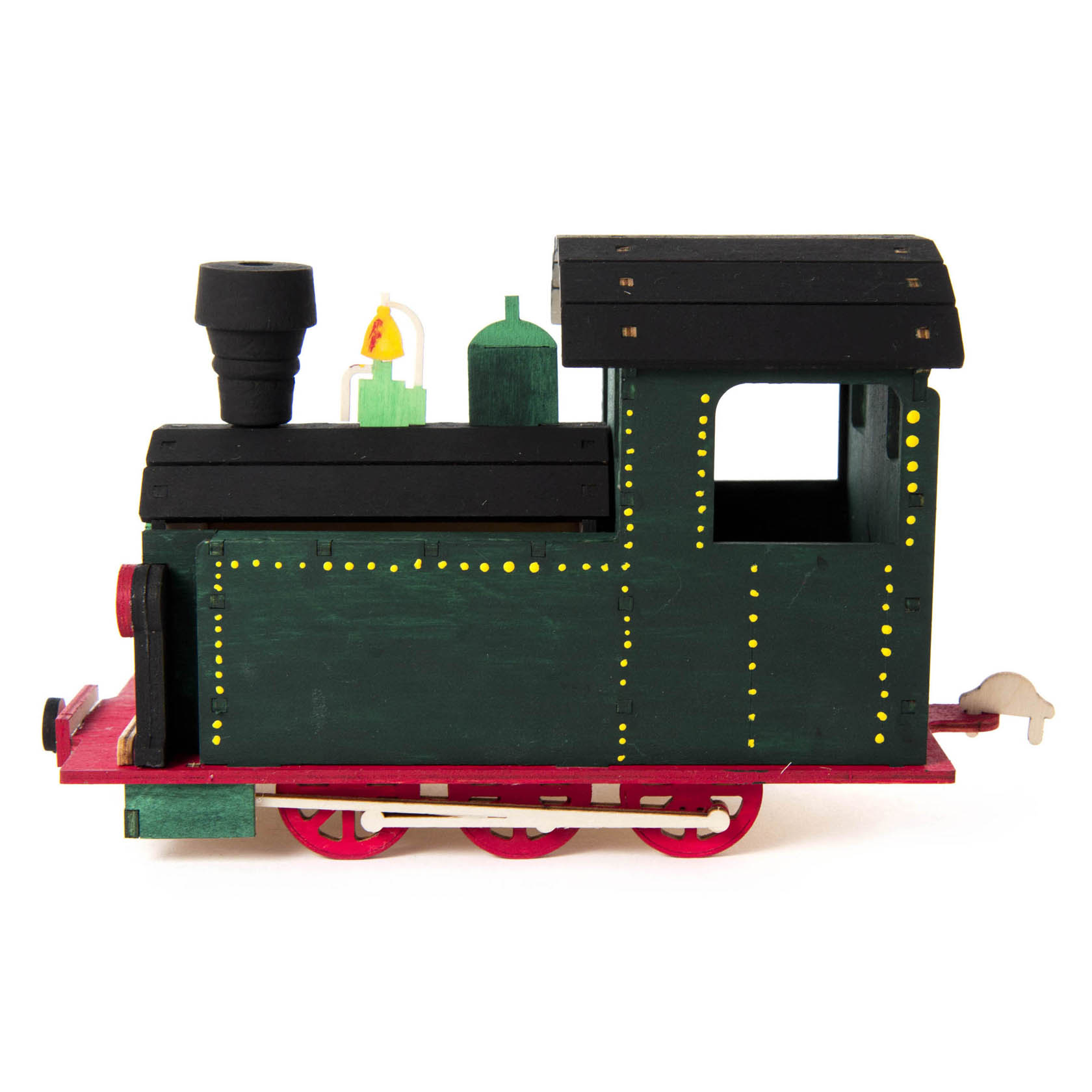 Ein handgefertigtes Räucherhaus in Form einer grünen Lokomotive mit schwarzen Dächern und roten Rädern auf einer Platte.