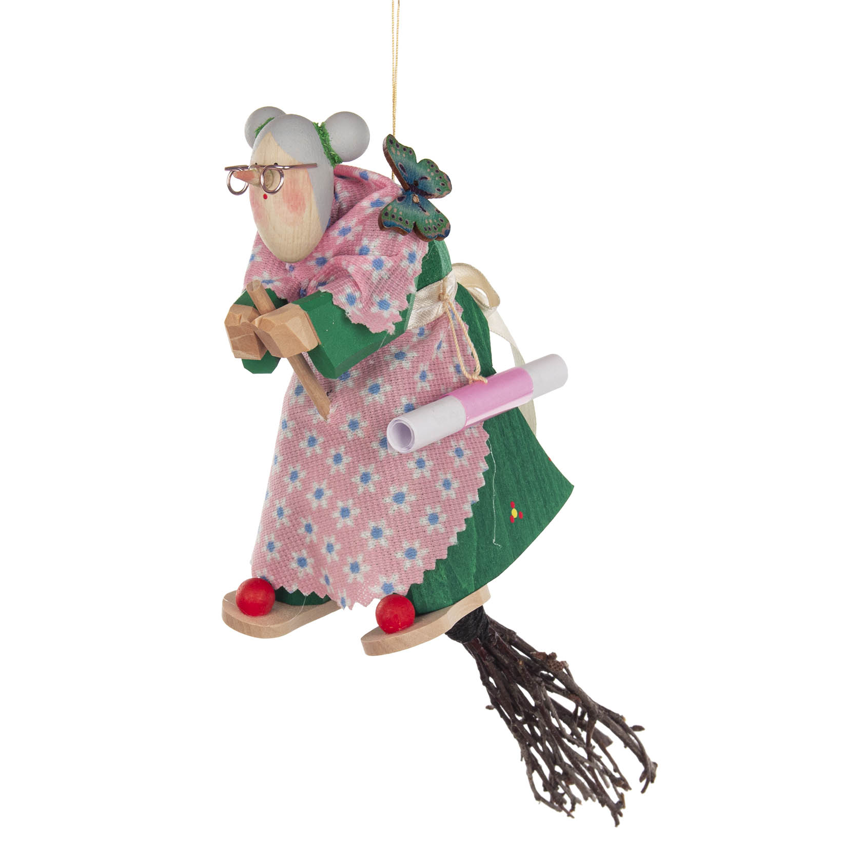 Holzfigur einer älteren Frau als Hexe mit Brille, grünem Kleid, rosa Schultertuch und Besen, zusätzliche Details: Schmetterling und Schriftrolle.