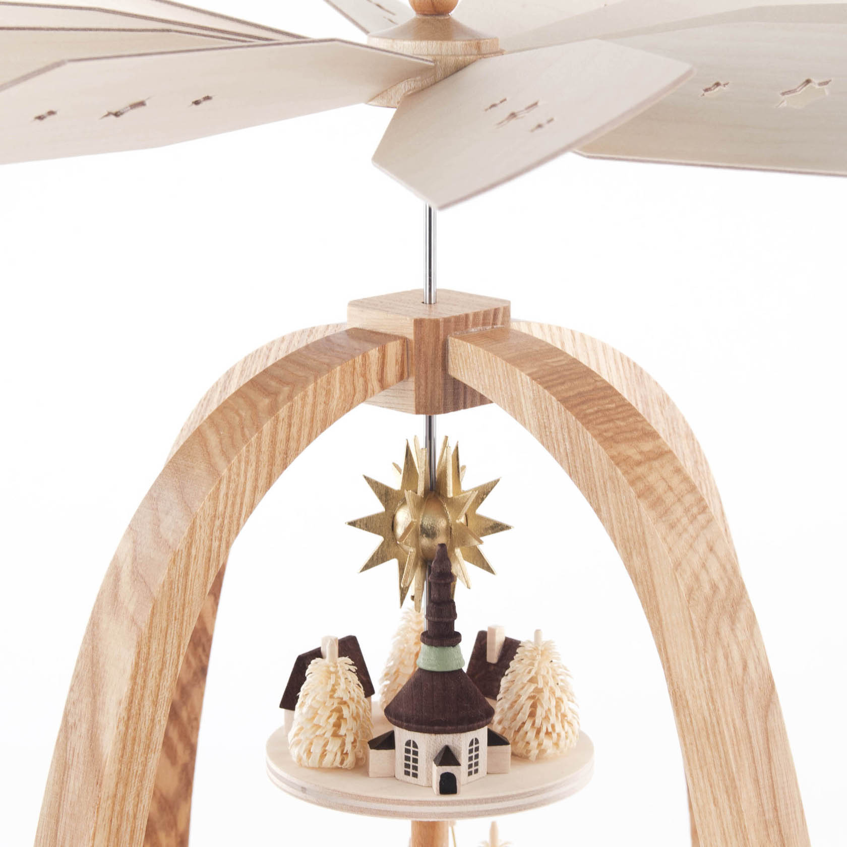 A three-tiered Seiffener Christmas pyramid featuring a central church figure surrounded by miniature wooden trees and houses, with a star at the top.