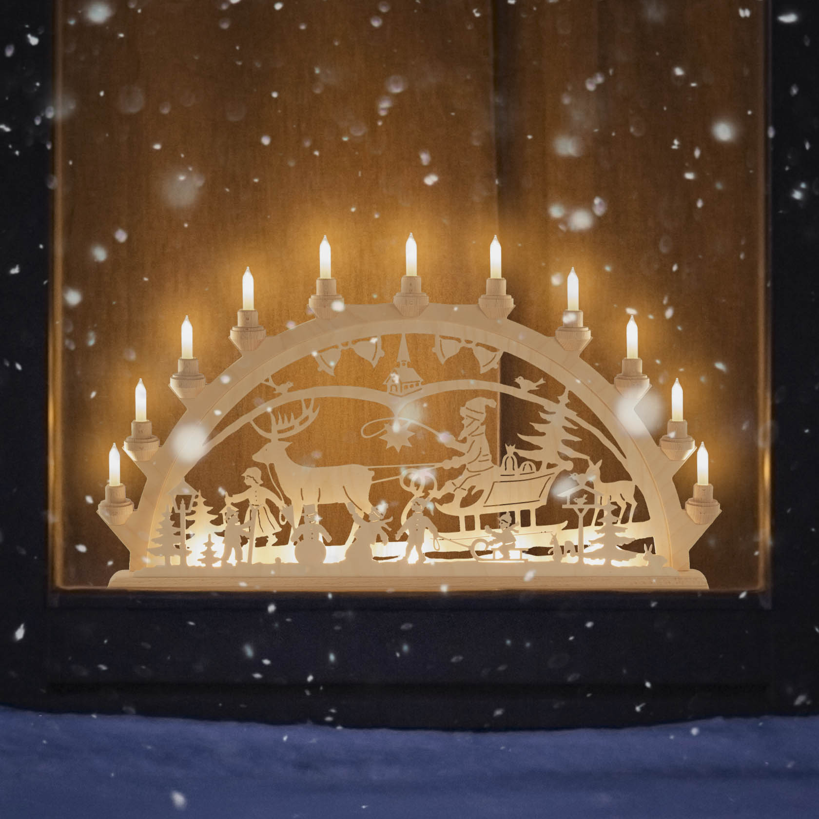 Elektrisch beleuchteter Schwibbogen zeigt ein Weihnachtsgespann mit Rentieren, einem Schlitten und Winterkindern in einer Schneelandschaft.