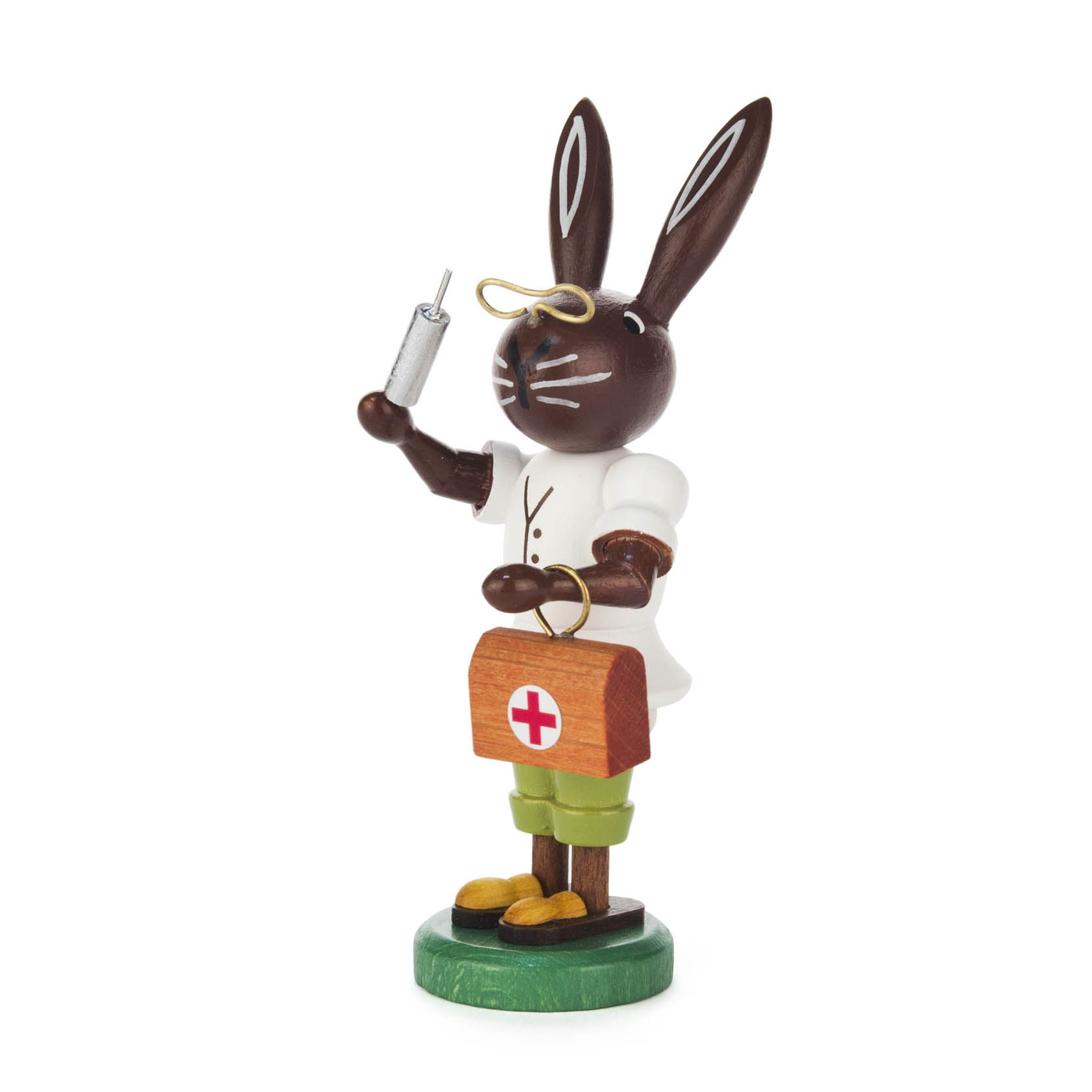 Ein hölzerner Hase in Arztkleidung mit einer Spritze in der Pfote und einer Arzttasche mit rotem Kreuz. im Dregeno Online Shop günstig kaufen