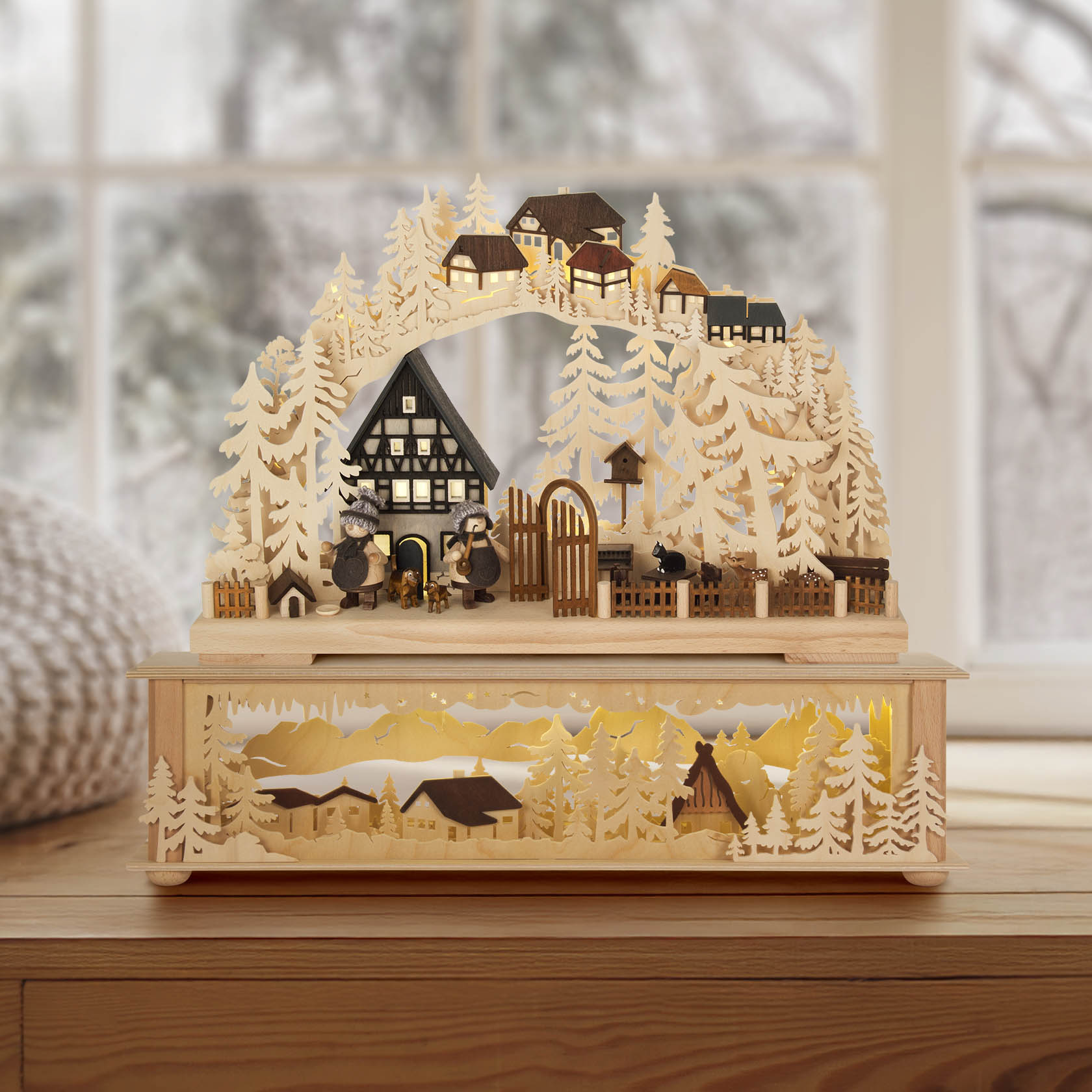 Ein kleiner Schwibbogen mit Fachwerkhaus-Design, indirekt elektrisch beleuchtet. Detailreiche Holzschnitzereien zeigen ein Fachwerkdorf und Waldlandschaft.
