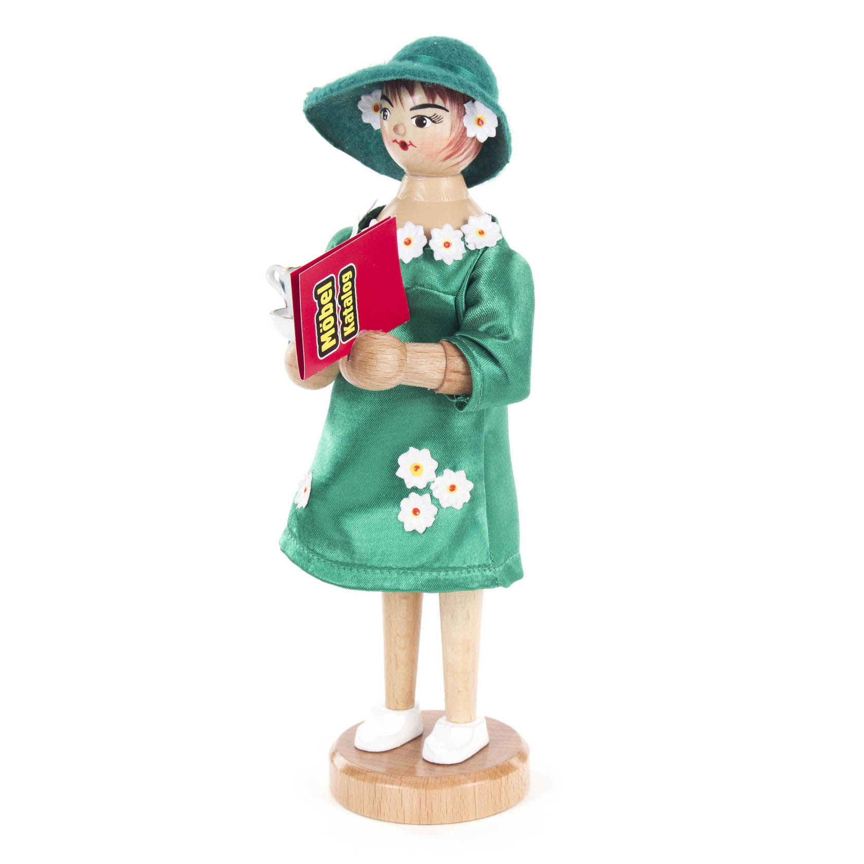 Räucherfigur einer Frau namens Yvonne mit grünem Hut und Kleid, Blumenmuster, hält ein rotes Buch mit der Aufschrift 'Duden'.