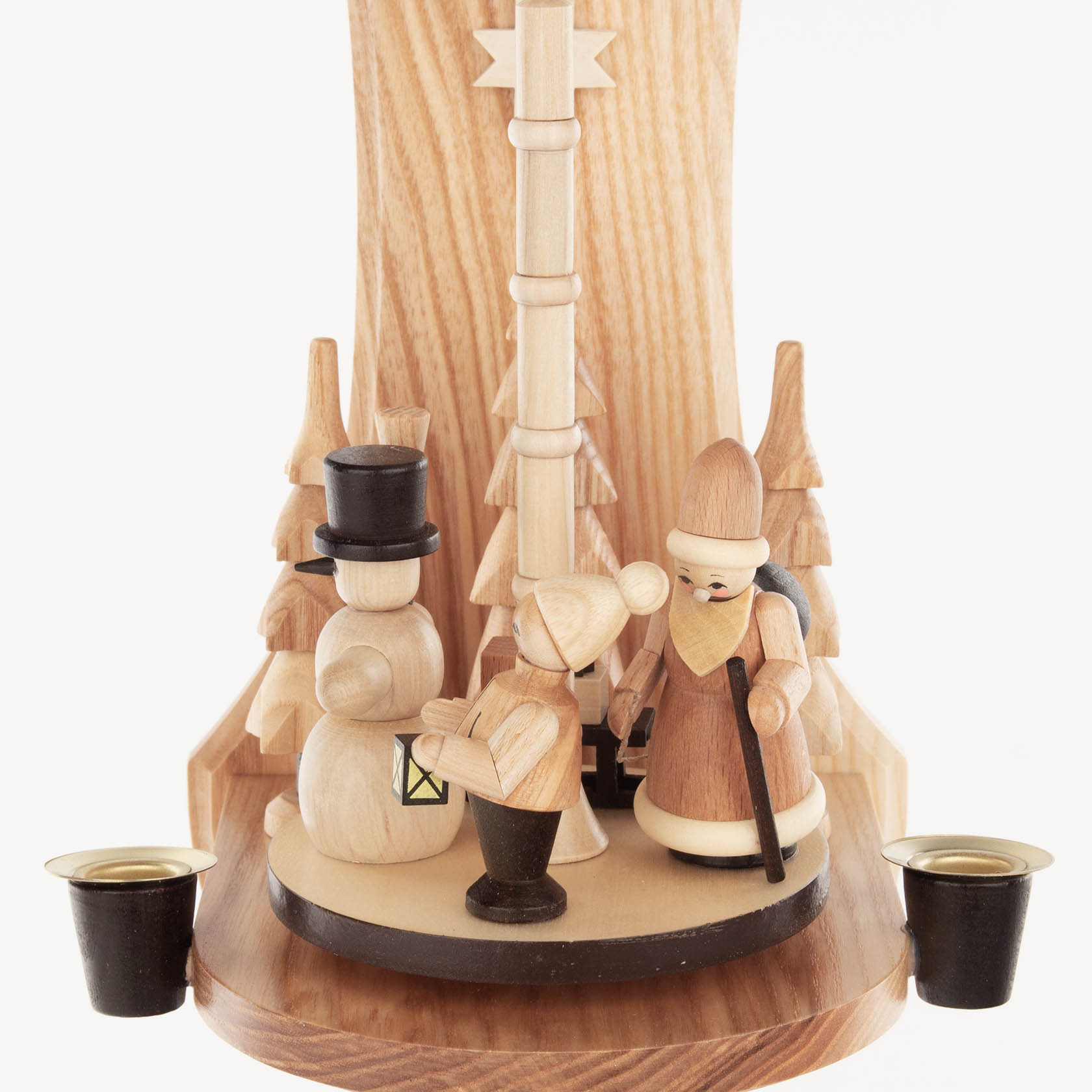 Holz-Wandpyramide mit Schneemann, Kind und Frau, figürlich dargestellt, umgeben von kleinen Tannenbäumen. Zwei Kerzenhalter an der Seite für Kerzen.