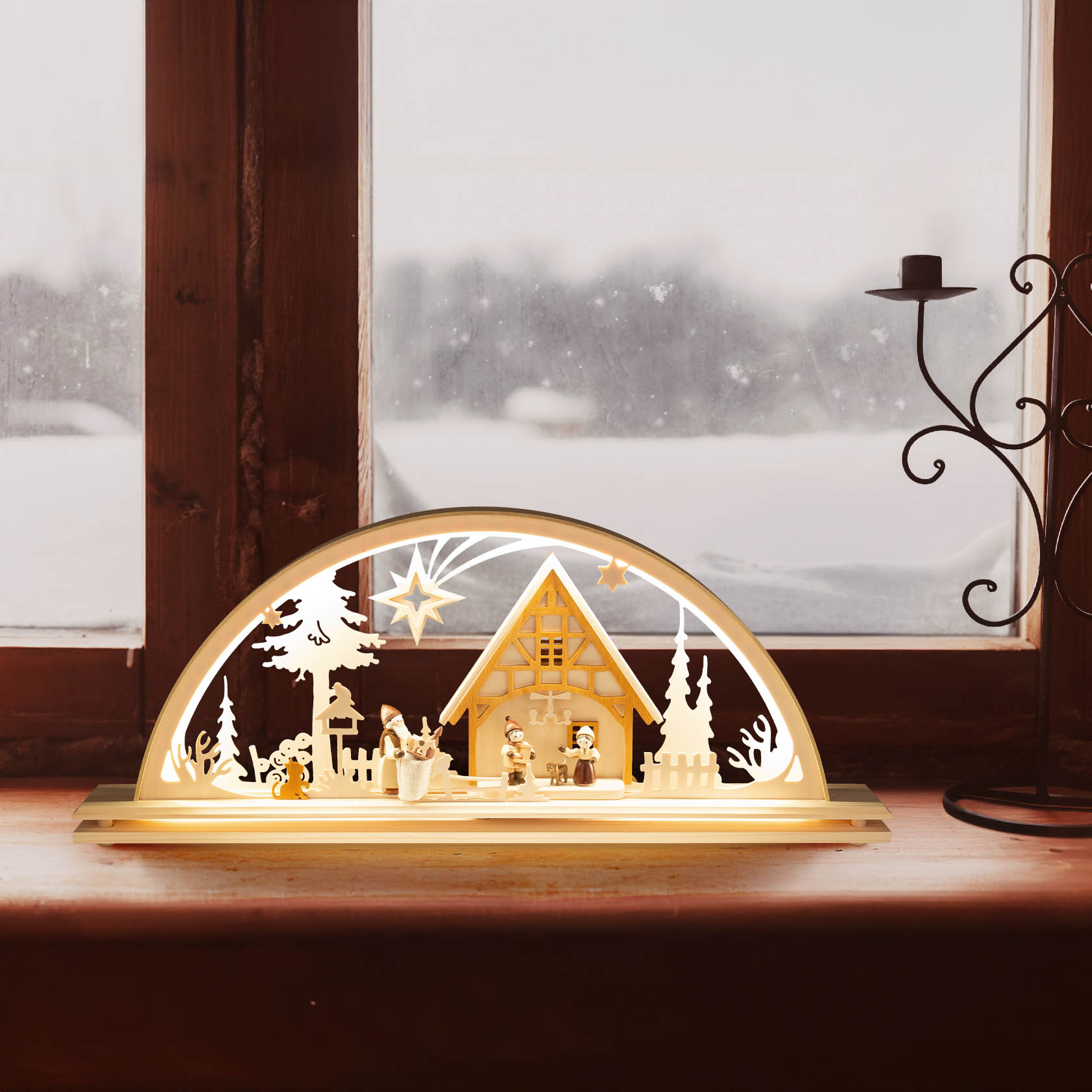 A wooden arch-shaped Christmas scene, featuring a house with figures in winter attire and a star overhead, illuminated by LED lights.