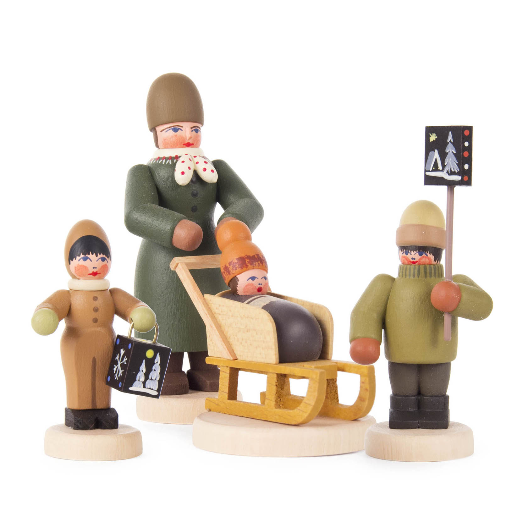 Wooden figurines of a mother with a sled and two children, all holding black signs with festive decorations, dressed in winter clothing. im Dregeno Online Shop günstig kaufen