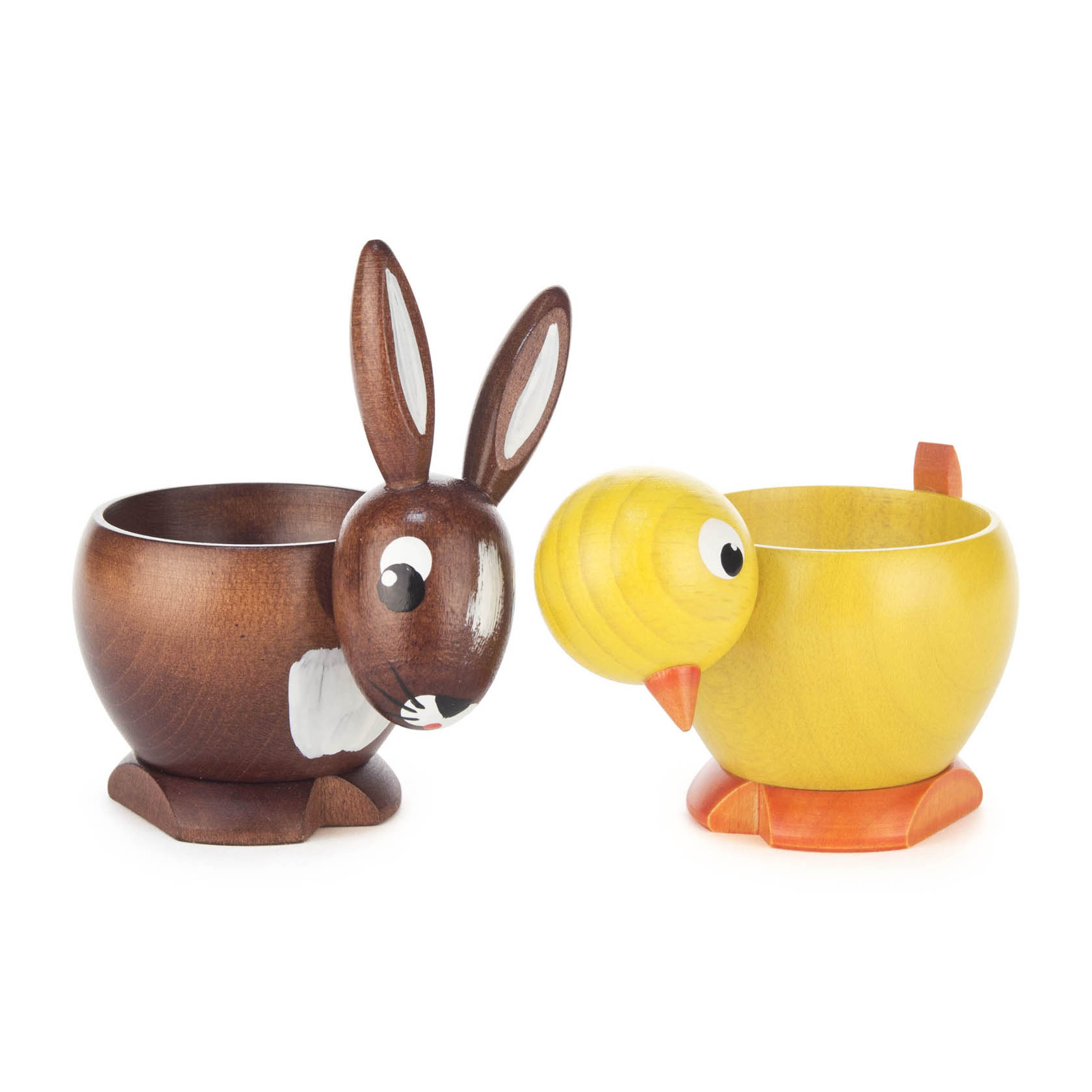 Zwei Eierbecher in Form eines braunen Hasen und eines gelben Kükens, beide mit niedlichen Augen und Details versehen.