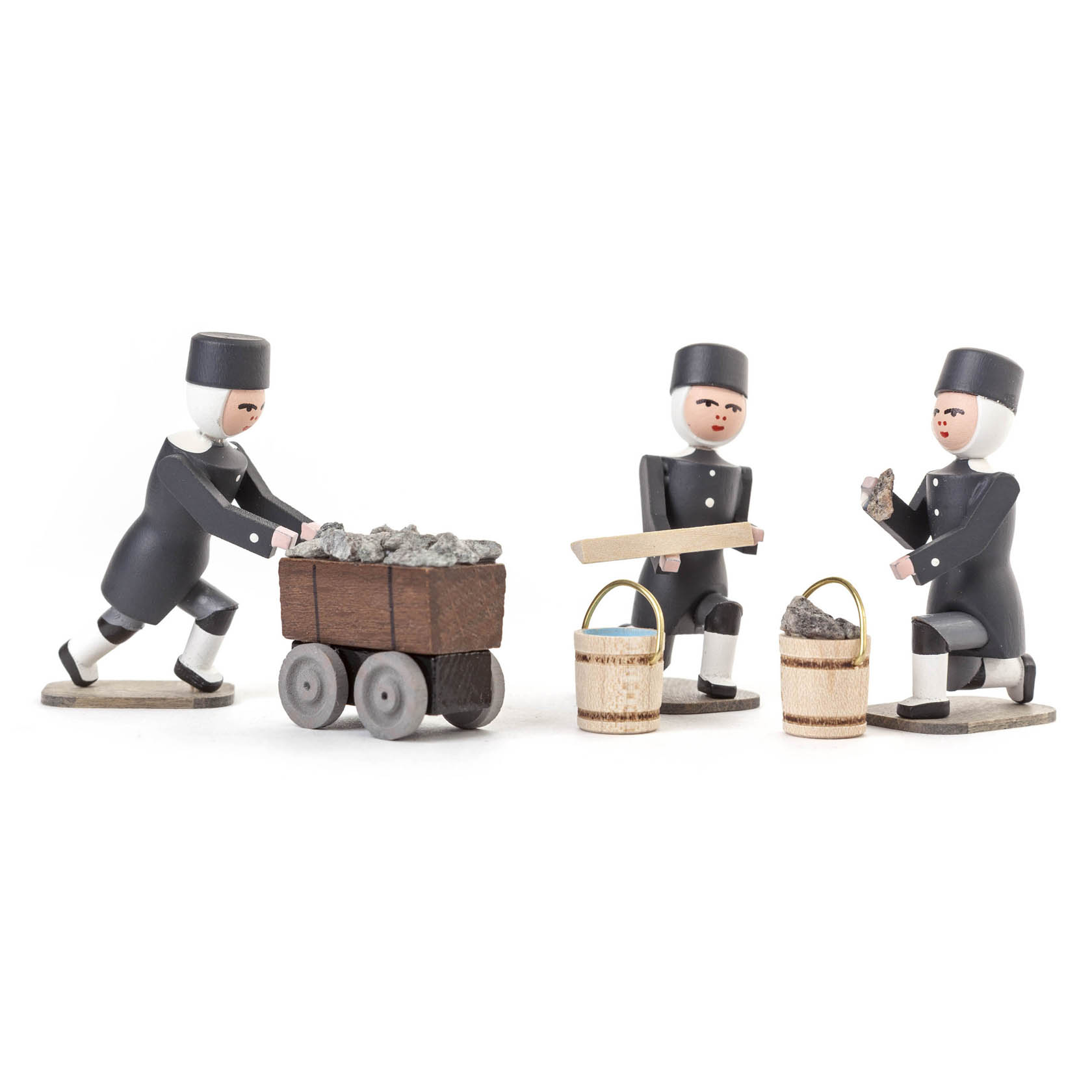 Drei Holzfiguren in Bergmannsuniformen. Einer schiebt einen Wagen mit Steinen, ein anderer hält ein Holzbrett, und der dritte hält einen Stein mit zwei Eimern.