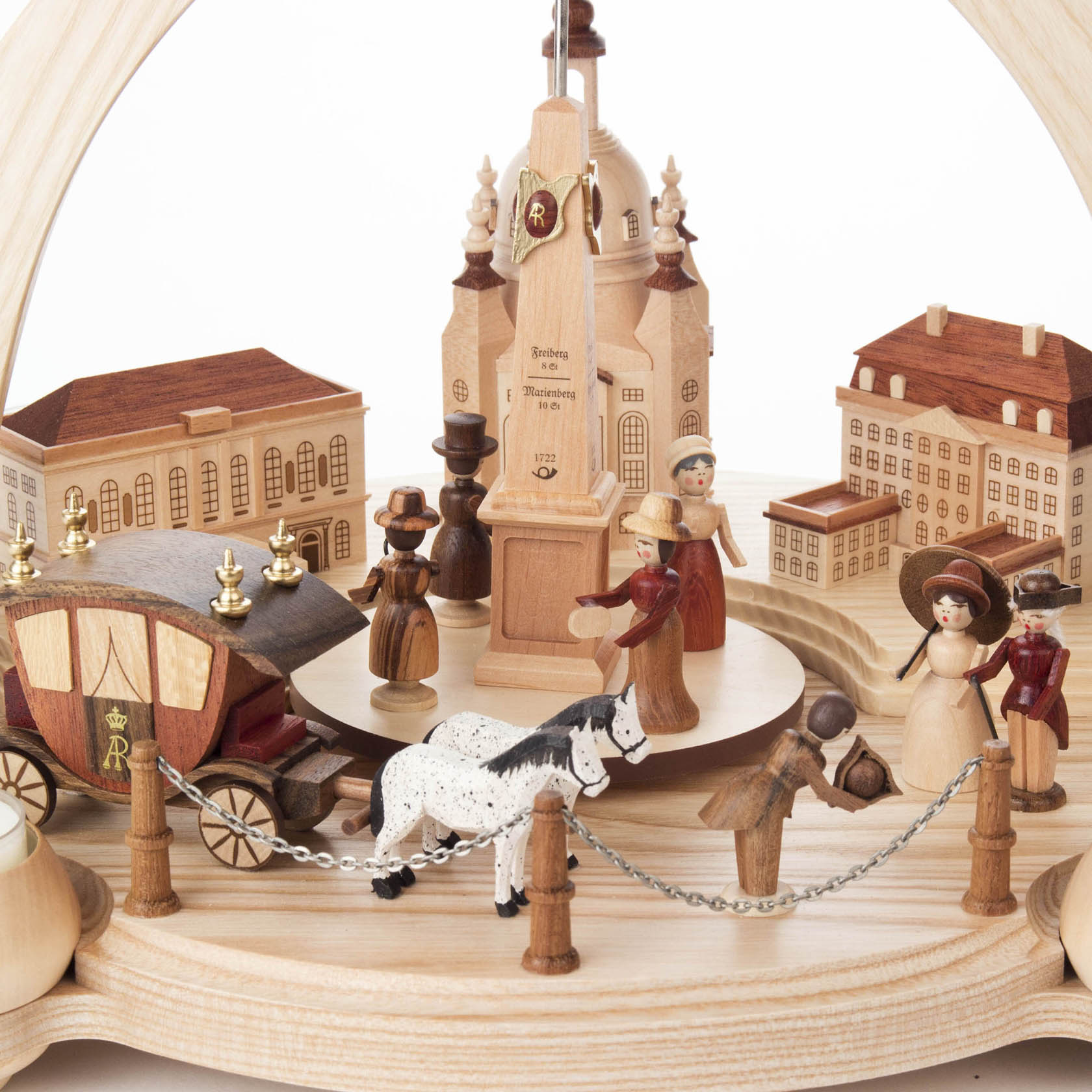 Holzpyramide mit sächsischer Szenerie, gezeigt werden Figuren in historischer Kleidung, Kutsche mit Pferd und Dresden-Gebäude.