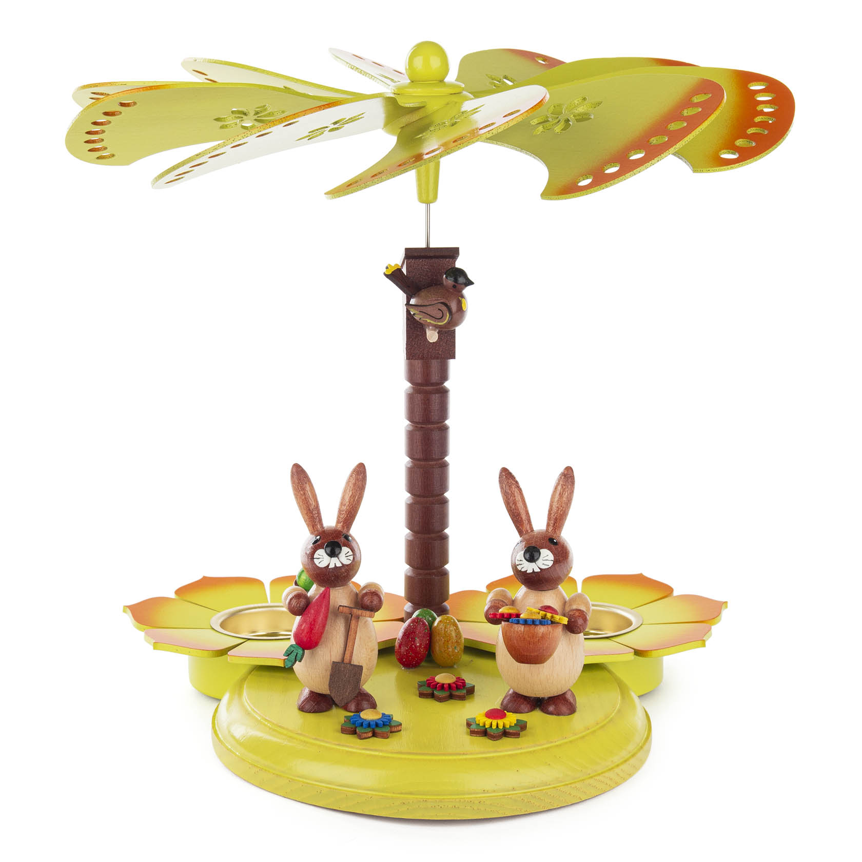 Colorful tea light pyramid with two bunnies. One holds a carrot, the other a basket, both stand on a green base with floral decorations.