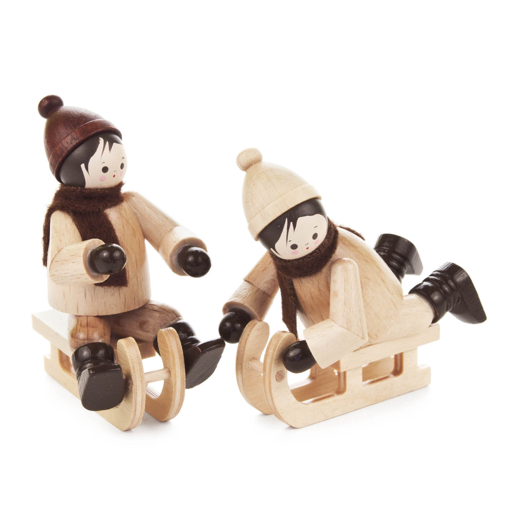 Zwei Holzfiguren von Kindern im Winterkleidung auf naturfarbenen Holzschlitten, braune Mützen und Schals, schwarze Schuhe und Handschuhe.