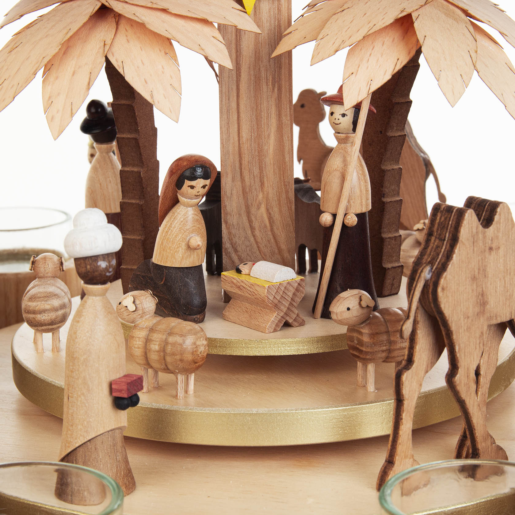Wooden nativity scene pyramid with figures including Mary, Joseph, Baby Jesus, shepherds, and sheep, featuring two candle holders and fans.