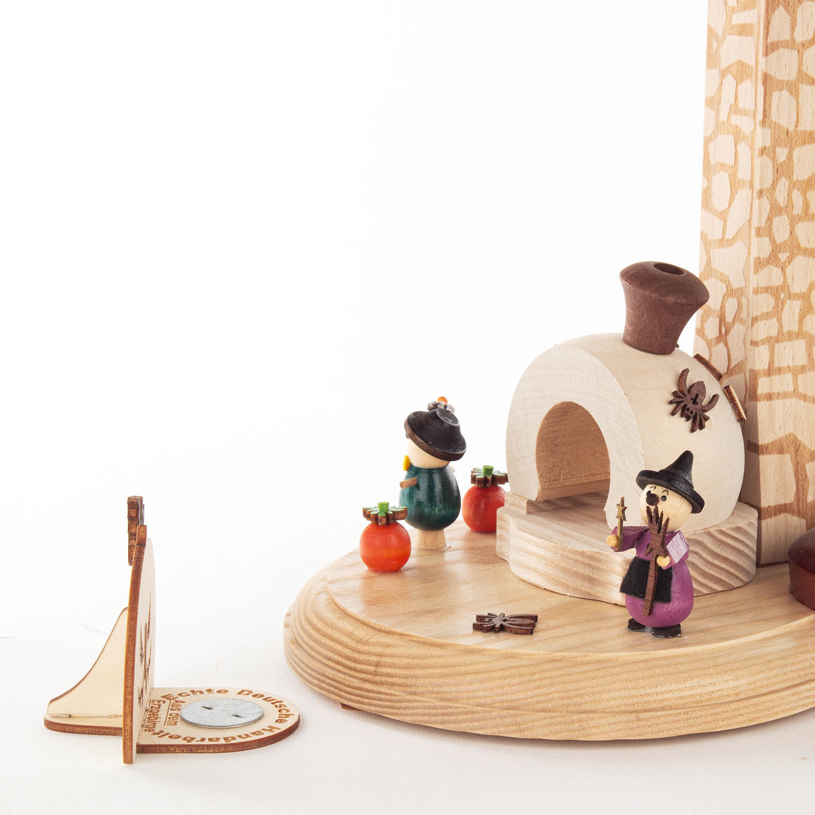 Eine handgefertigte Holzräucherpyramide mit Halloween-Motiv für Teelichte. Ein kleiner Kamin mit einer Hexenfigur und Kürbissen dekoriert.