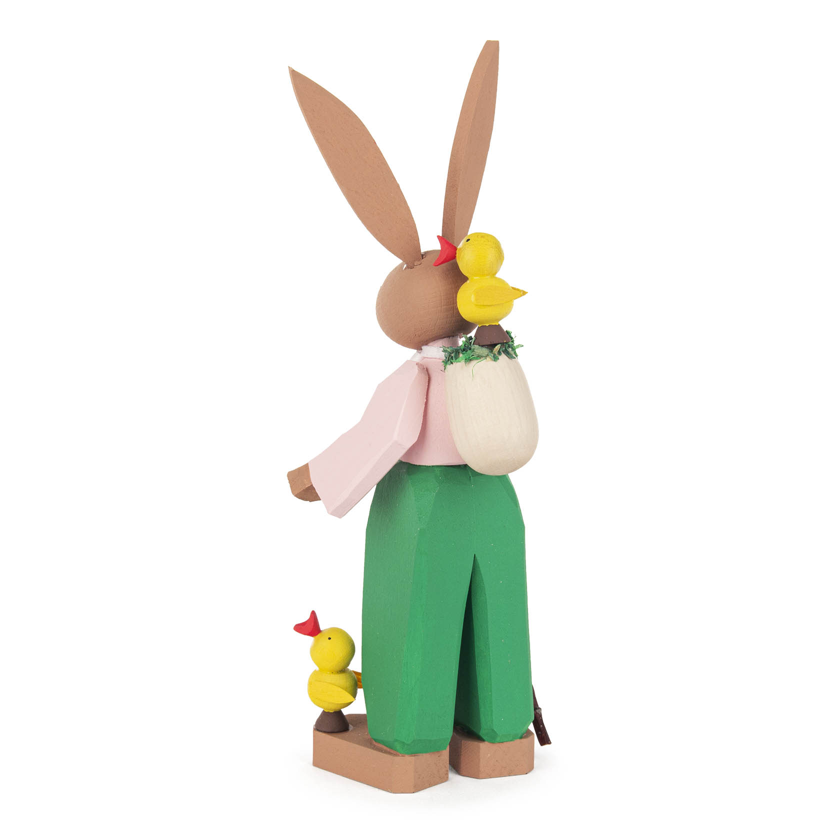 Wooden Easter Bunny Hugo with long ears, wearing green pants and a white shirt, holding a bag with yellow chicks on his shoulder and at his feet.