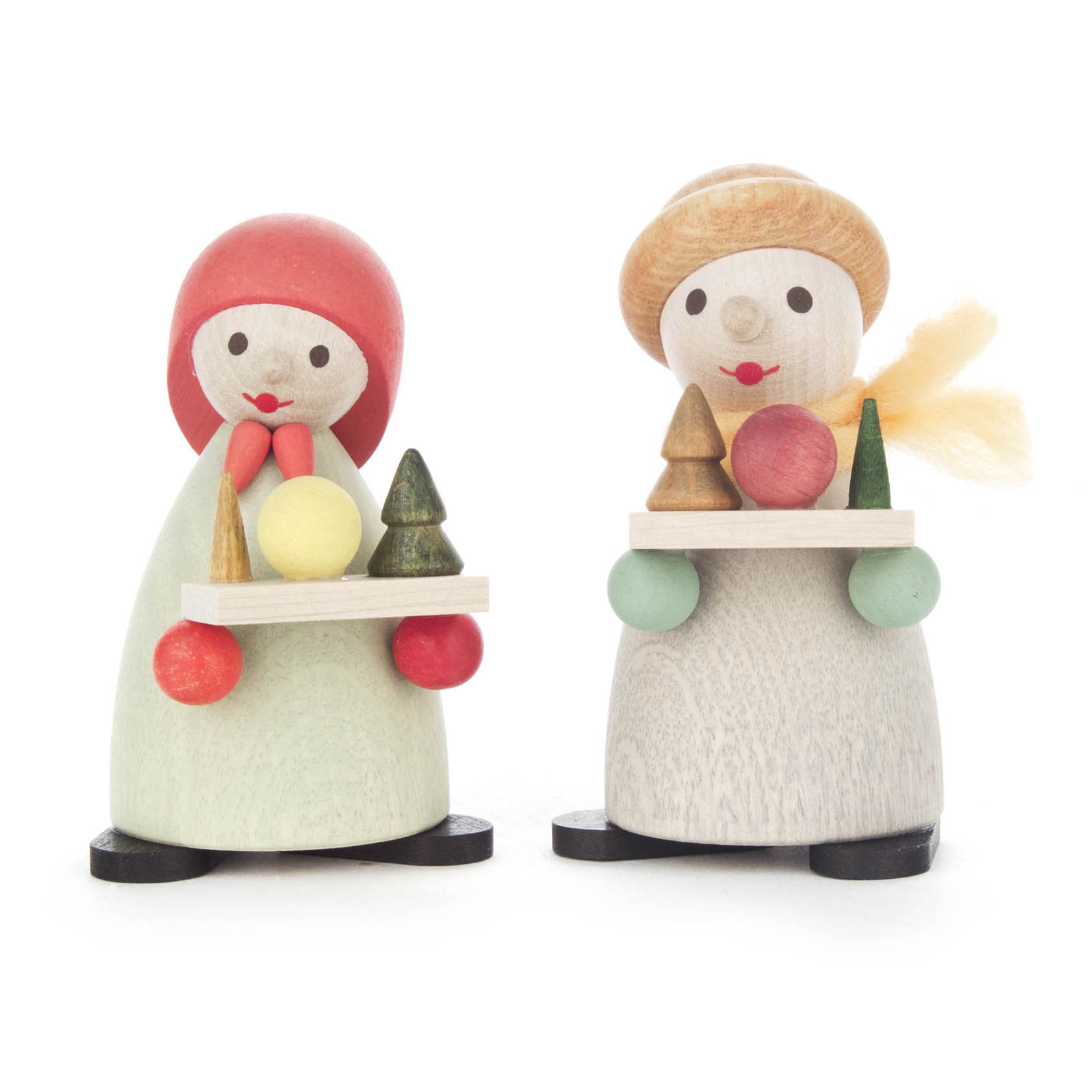 Two modern wooden Striezelkinder figures with colorful hats and scarves, holding trays with small pine trees and round objects. They have simple, painted faces. im Dregeno Online Shop günstig kaufen
