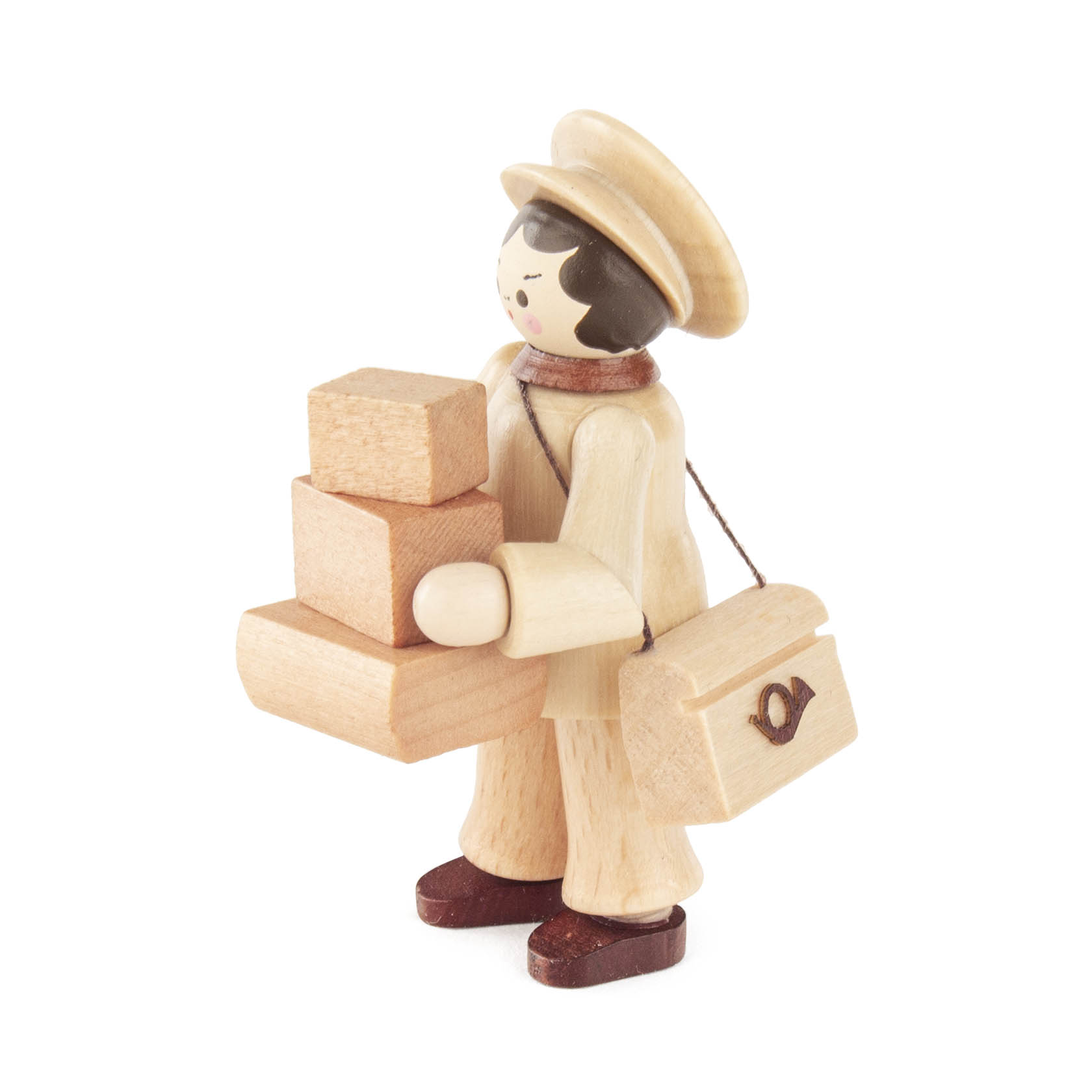 Wooden figurine of a mail carrier wearing a hat and scarf, holding stacked packages and a mailbag with a postal symbol.