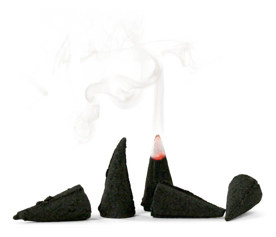 Several black incense cones with one emitting smoke, arranged upright on a white background.